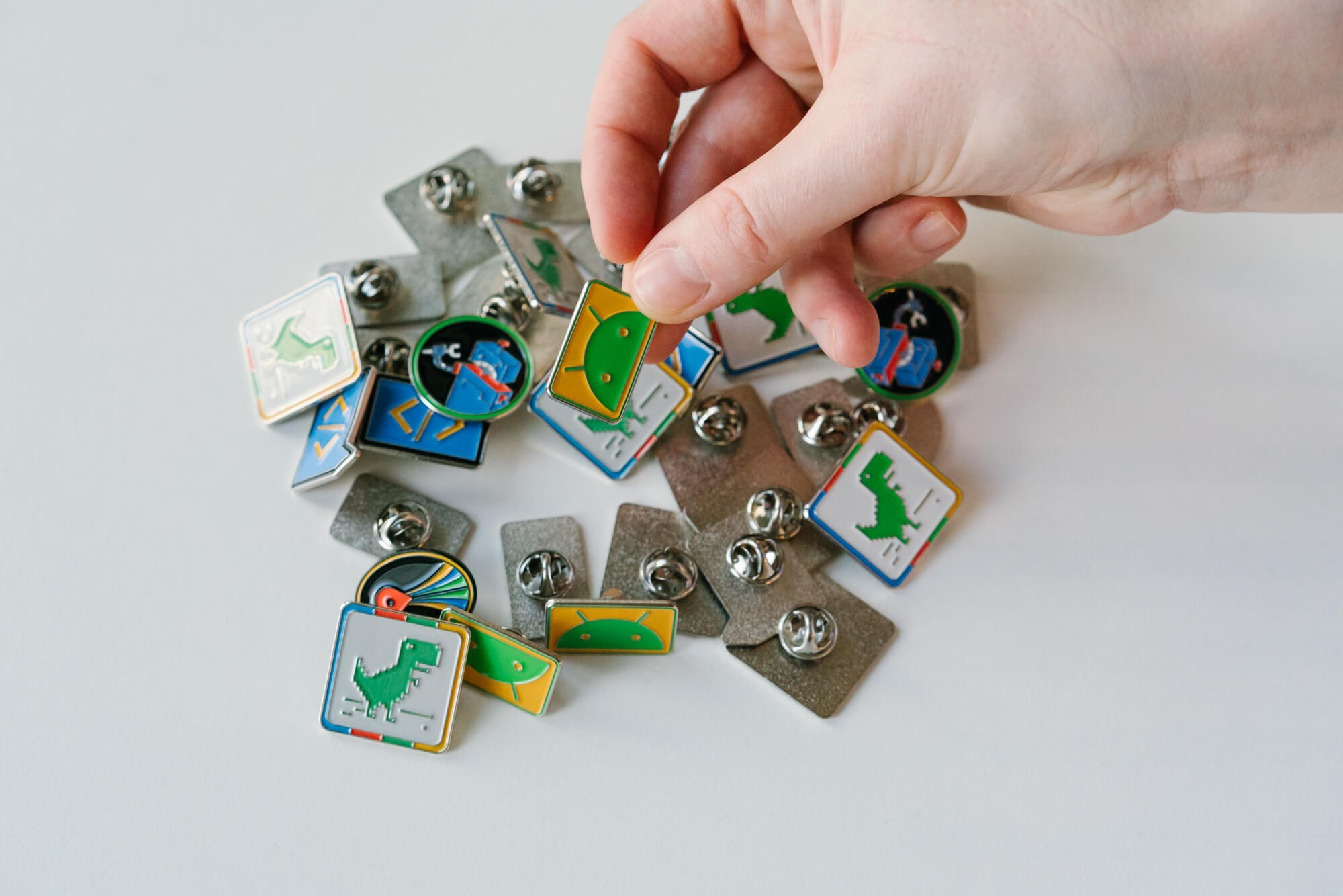 Nahaufnahme: Hände sortieren bunte Event-Badges und gebrandete Materialien