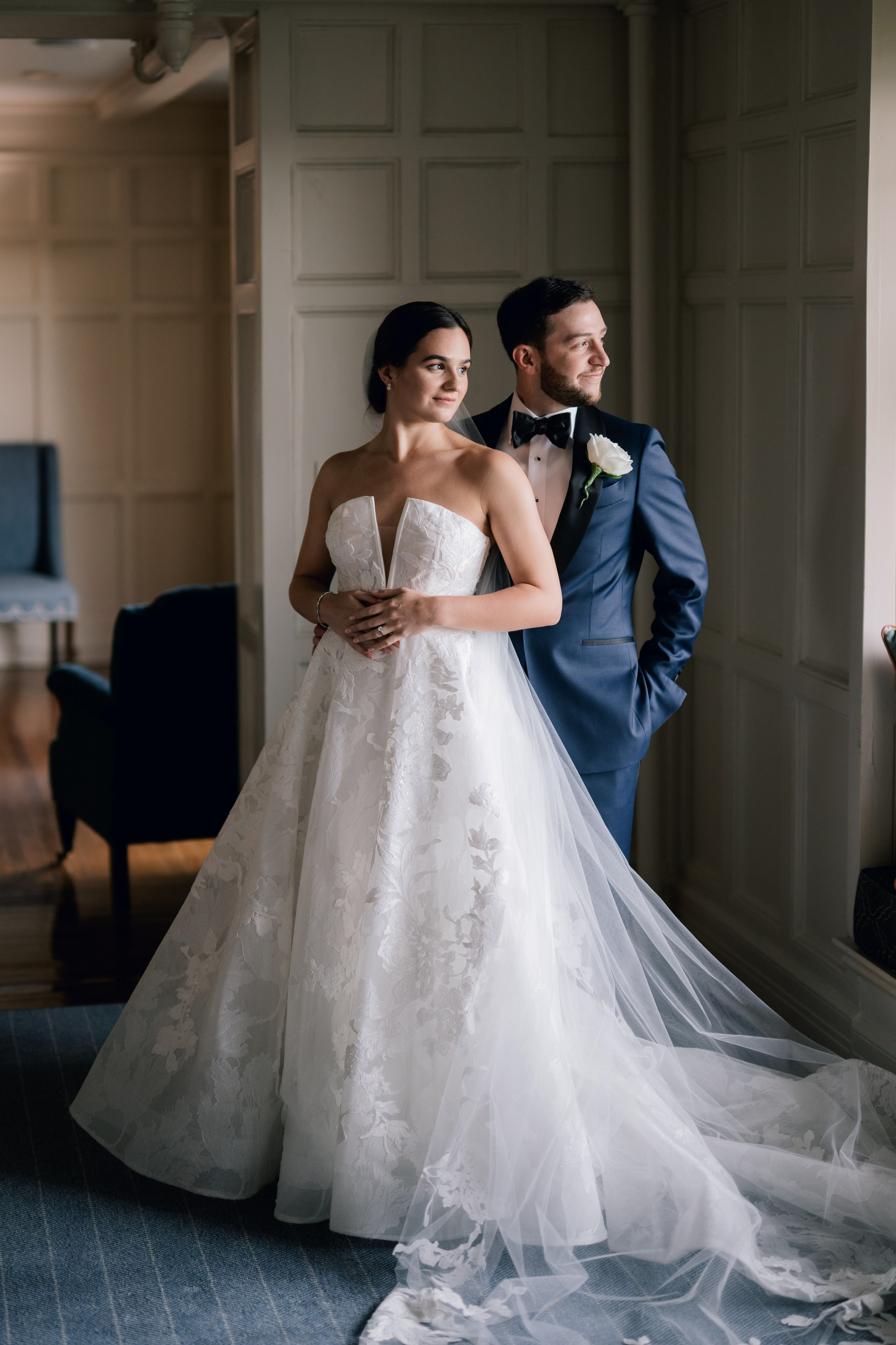 a bride and groom pose for a photo in a hotel room
