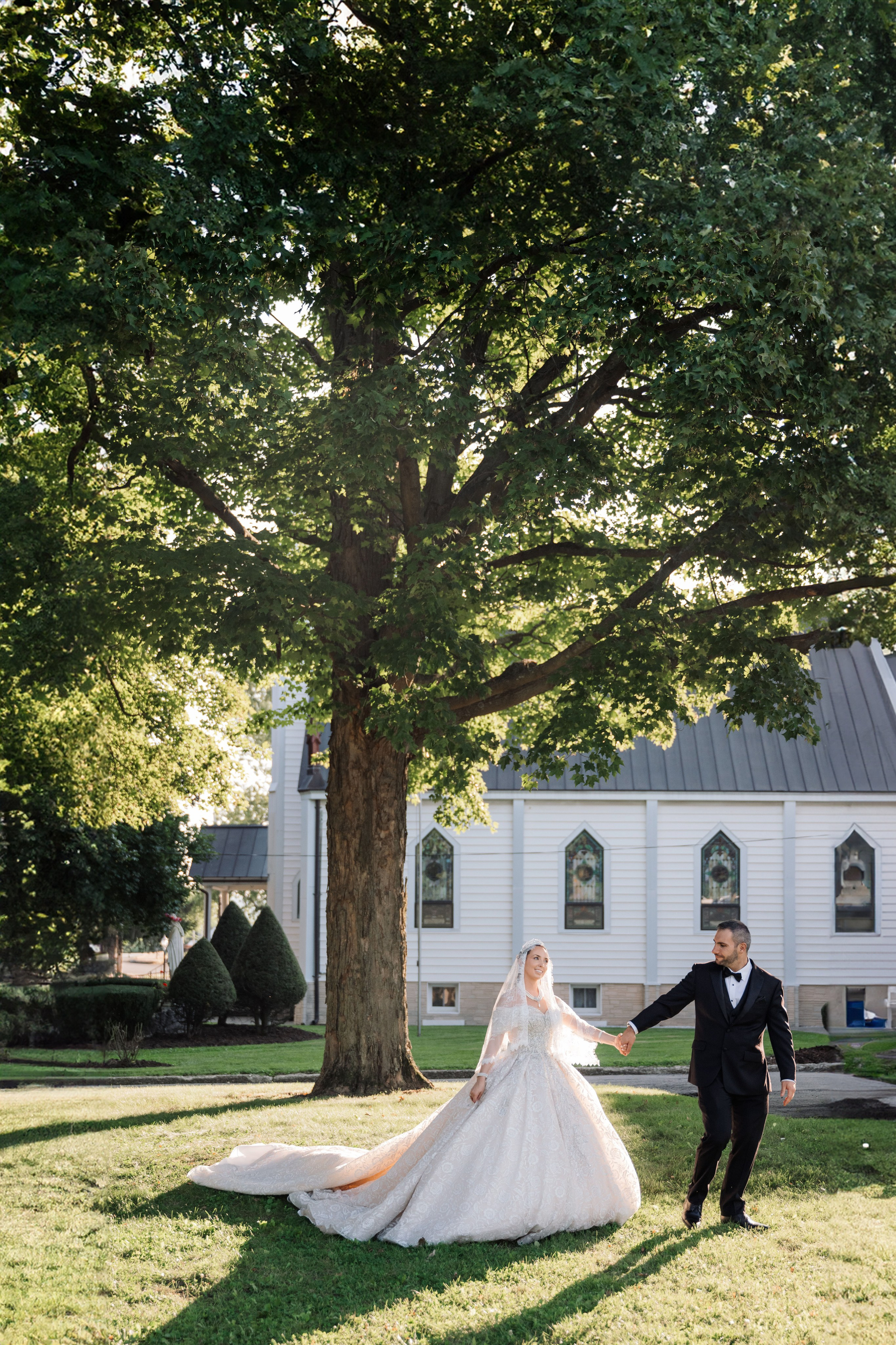 a bride and groom walking in front of a white house