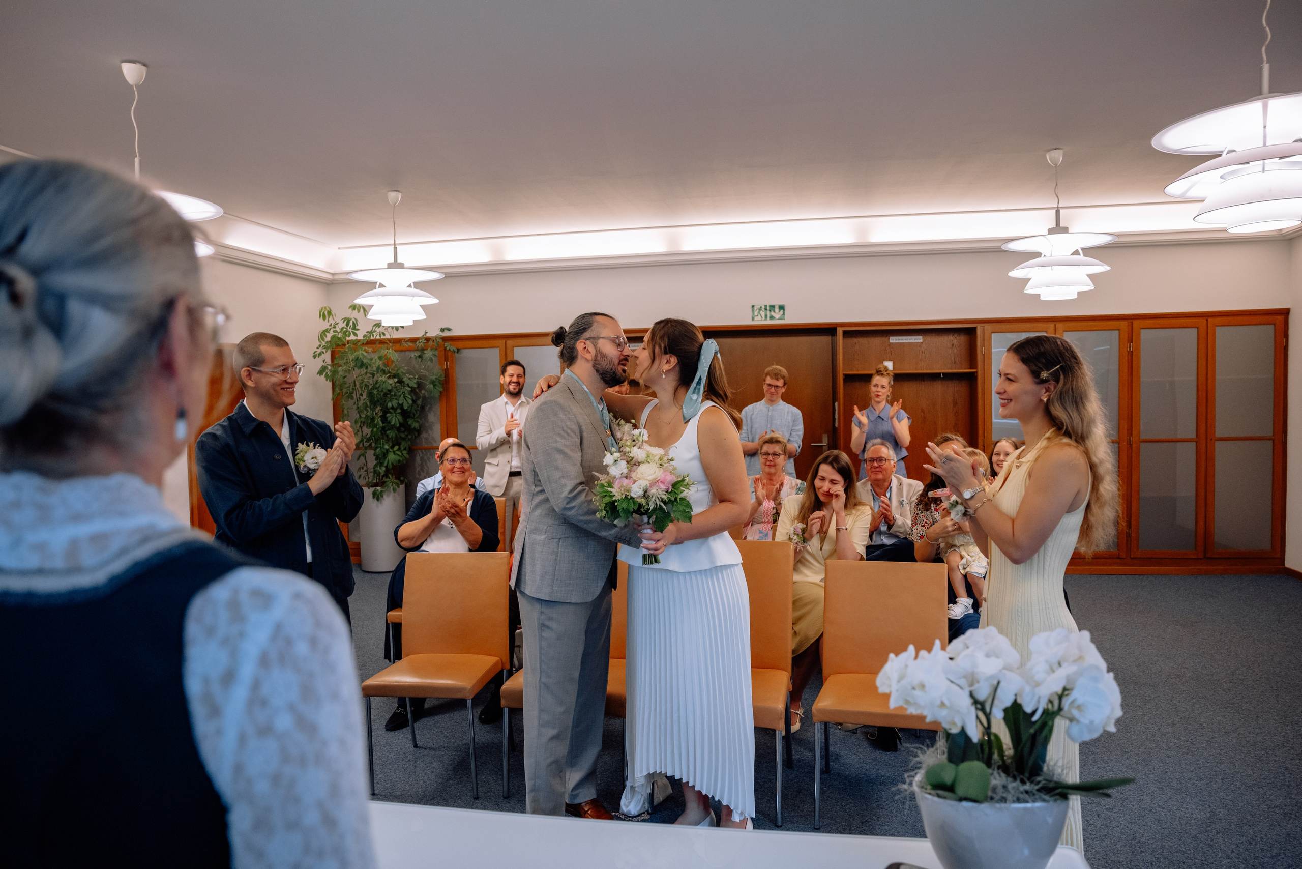 Brautpaar umarmt sich und küsst sich im Trausaal – emotionale Nahaufnahm