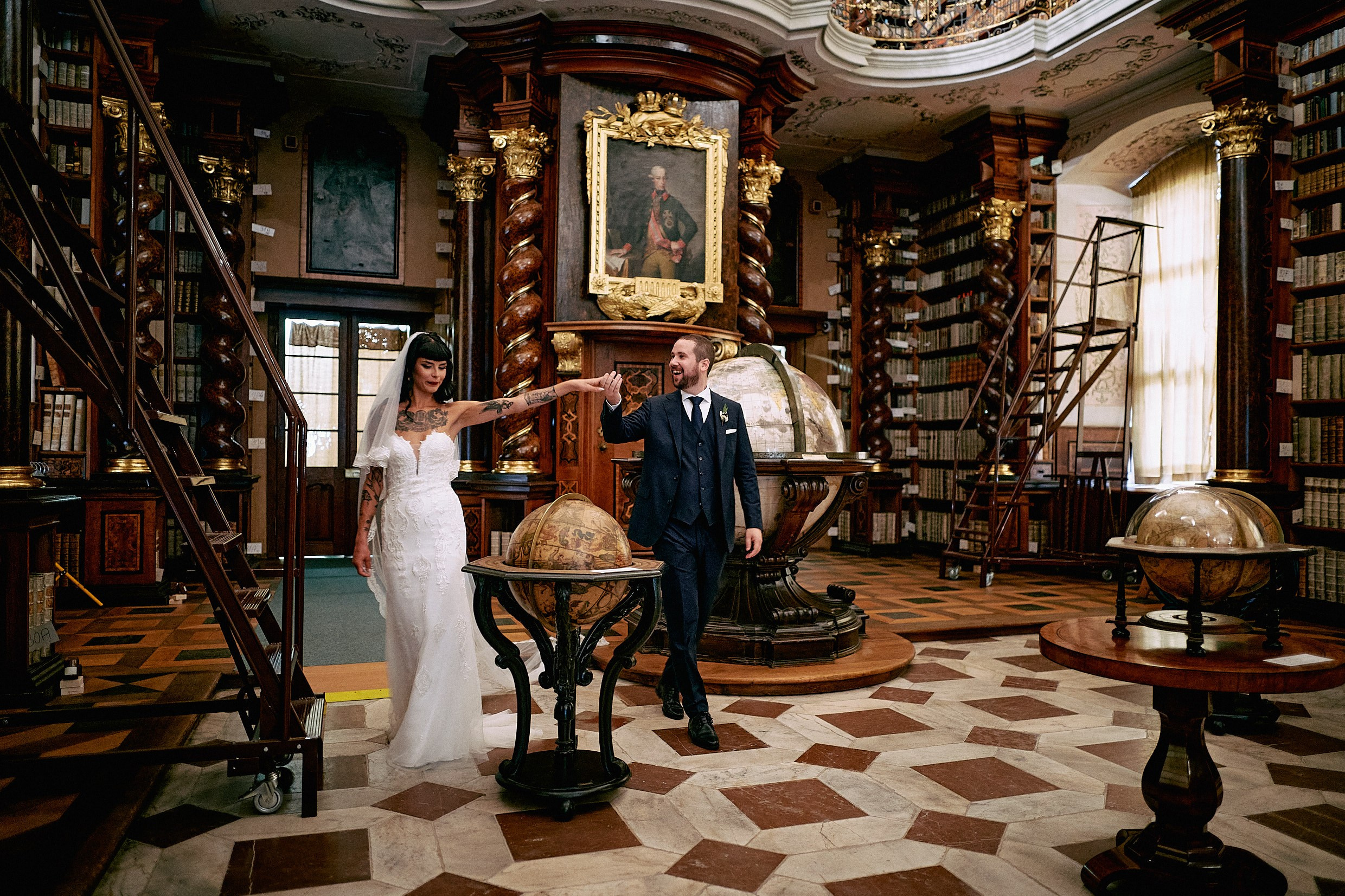 Newlyweds exploring antique globes in exclusive Klementinum Baroque Library.