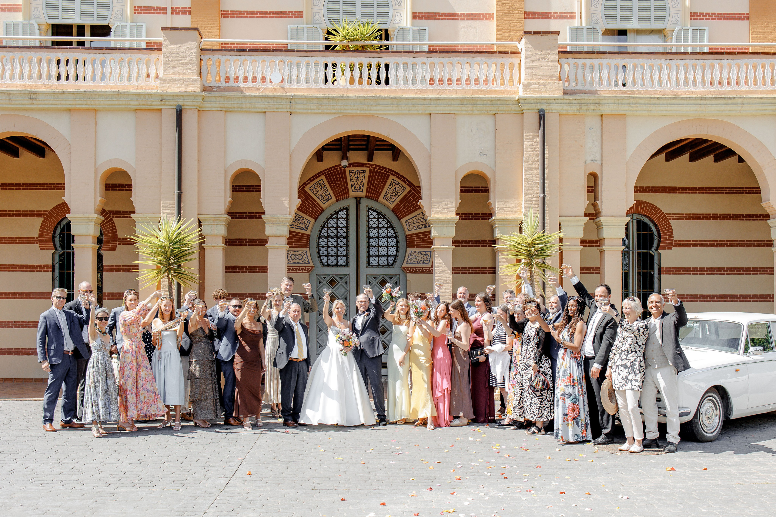 Friends and family gathered in front of the wedding villa, celebrating the newlyweds with laughter and joy.