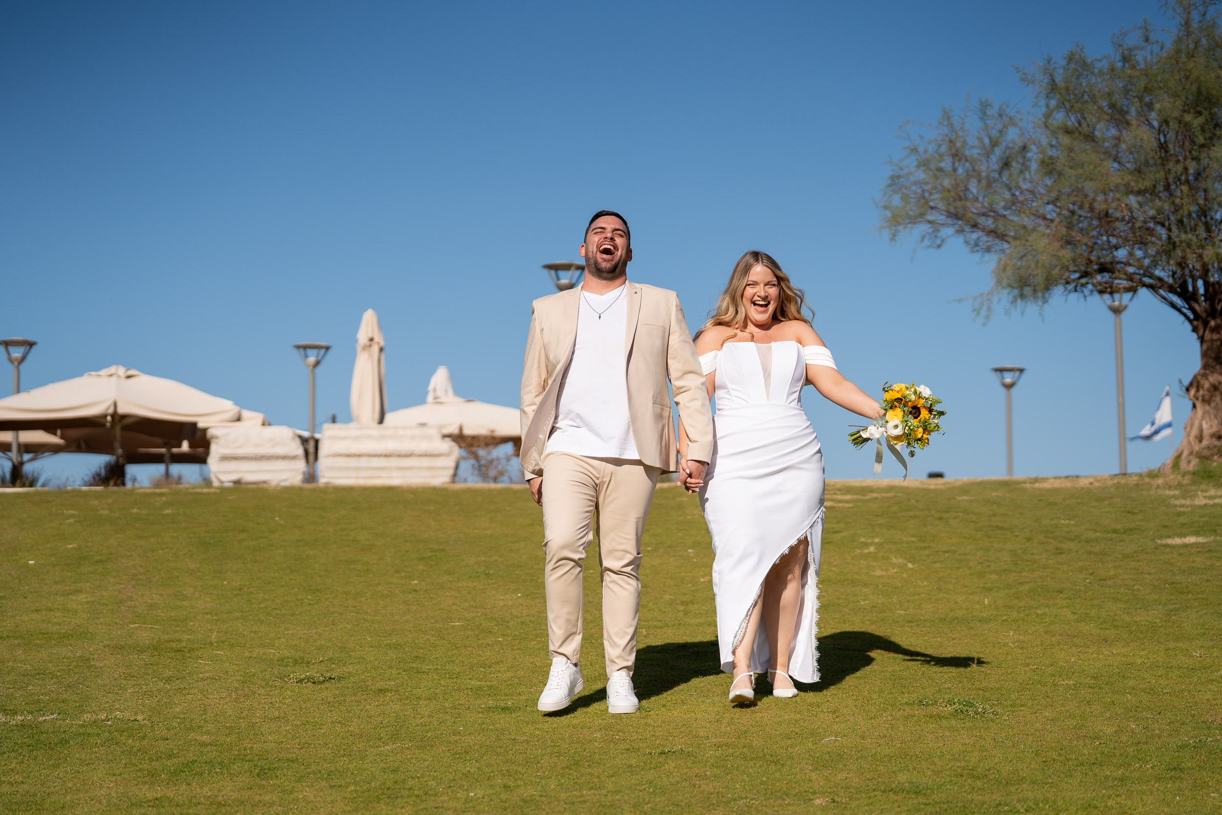 Yael and Natanel laugh as they walk hand in hand
