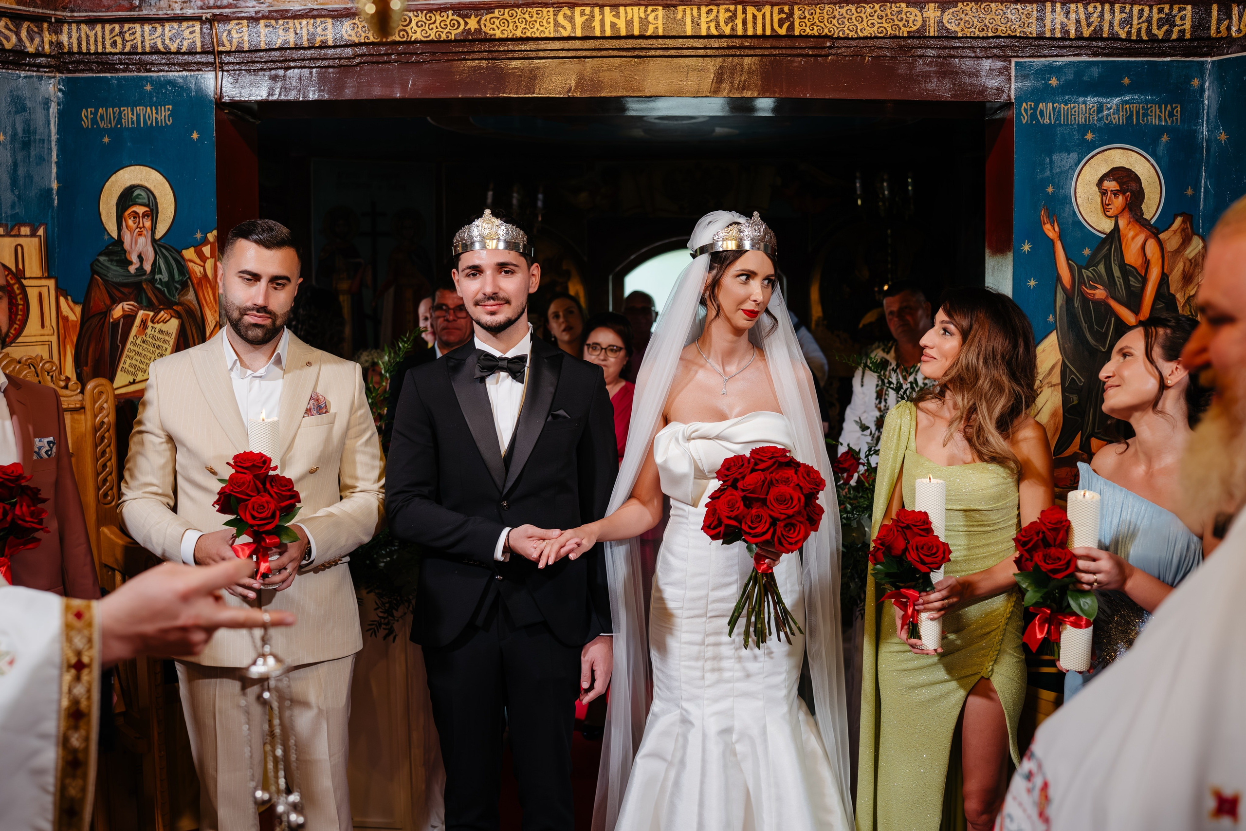Mirii împreună cu nașii în fața altarului, cununie religioasă la biserică.
