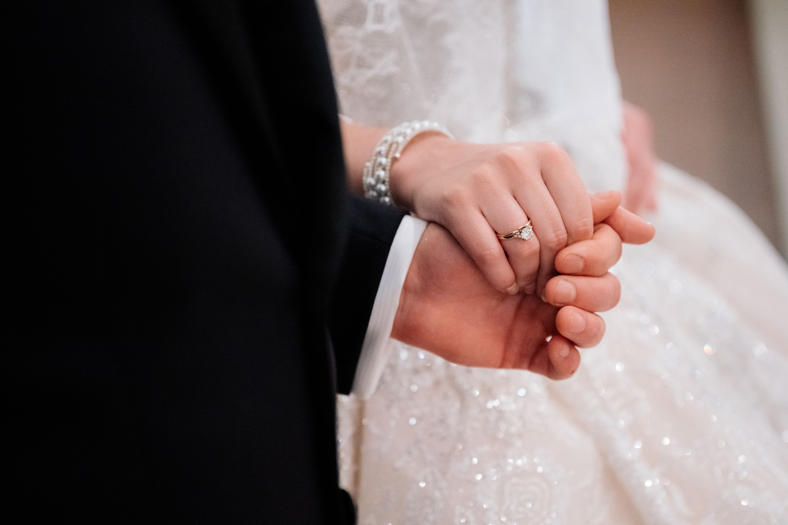 a close up of a person holding a wedding ring