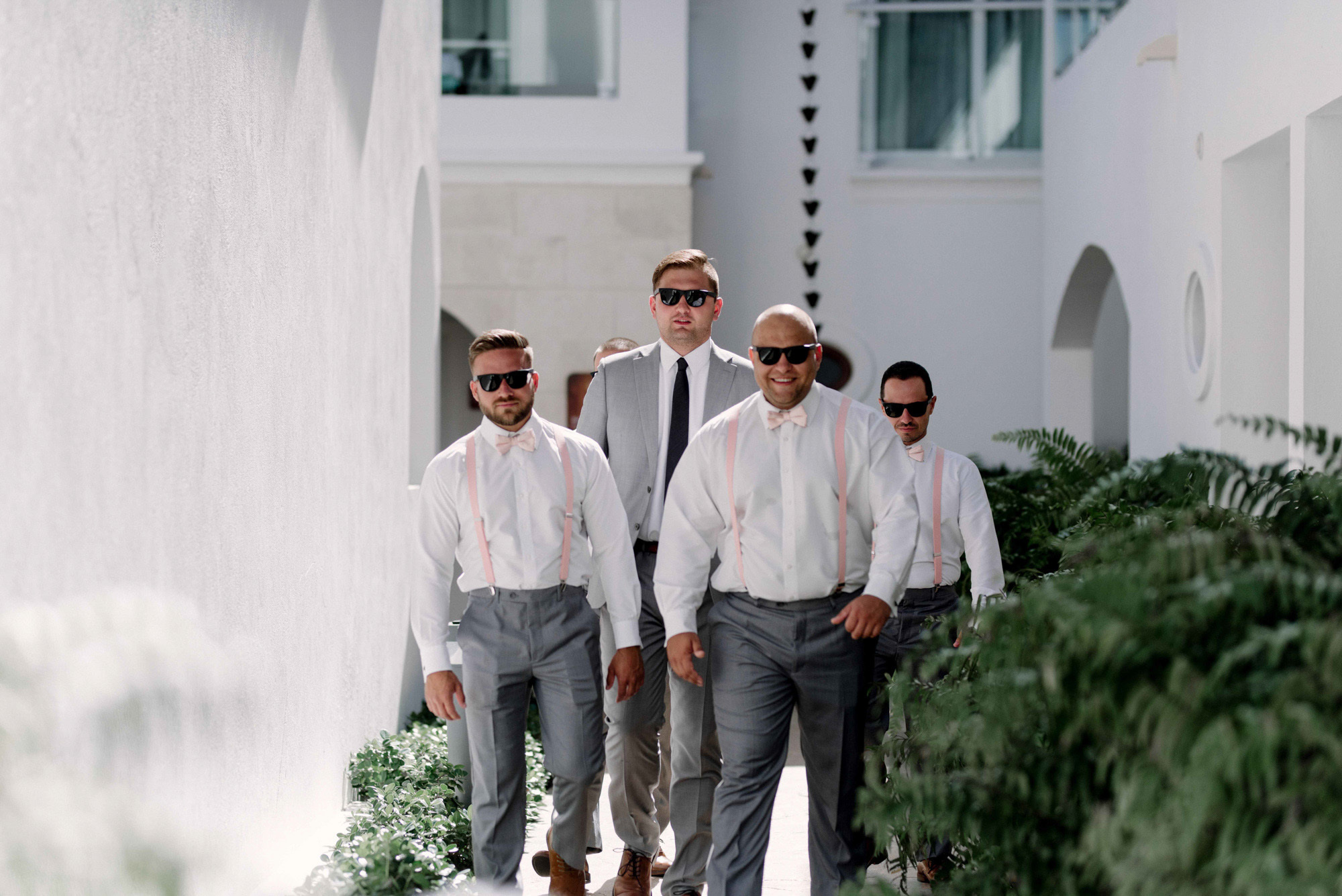 The groom, accompanied by friends, walks through the courtyard of the hotel.