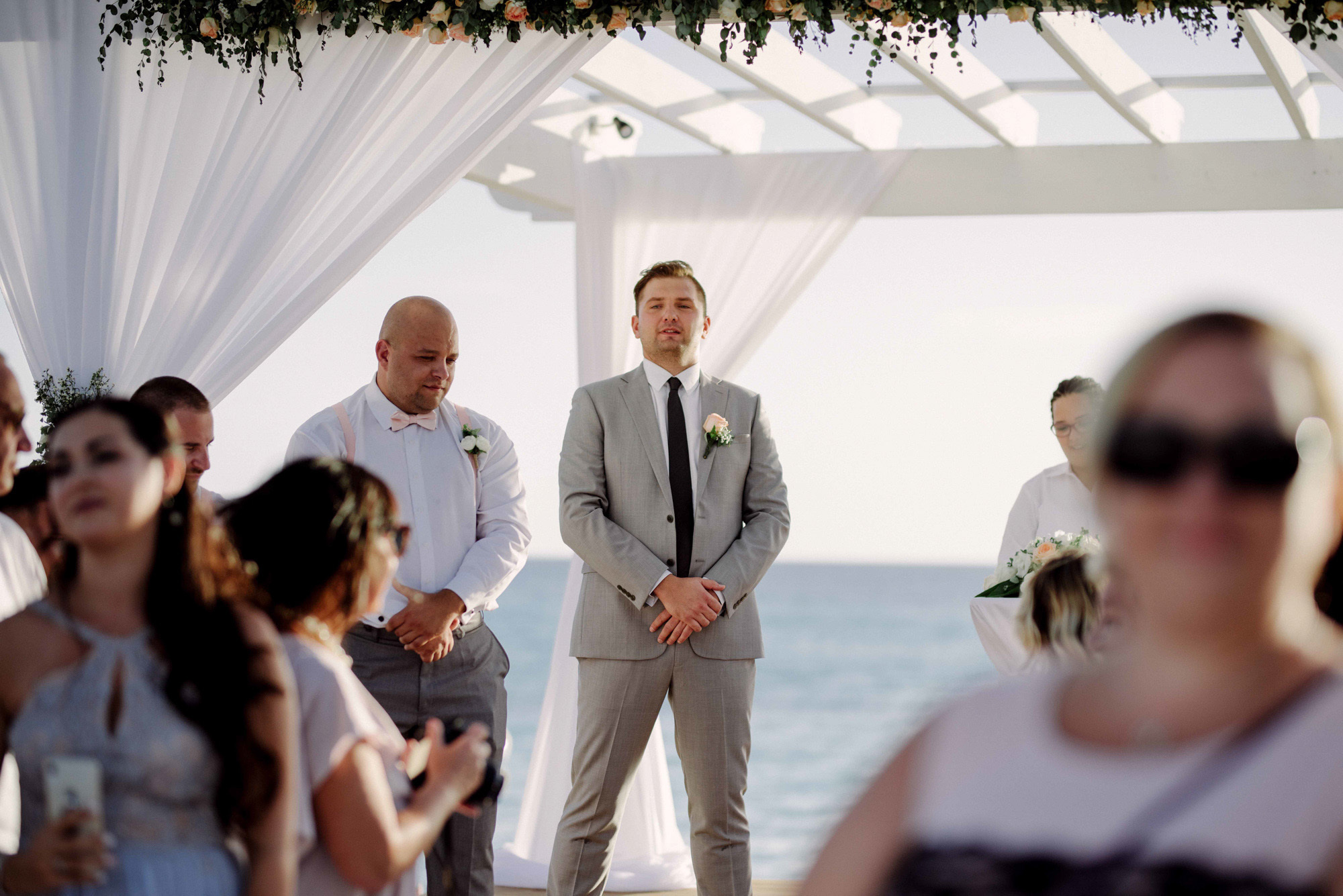 The groom and the pope are standing at the altar surrounded by guests.