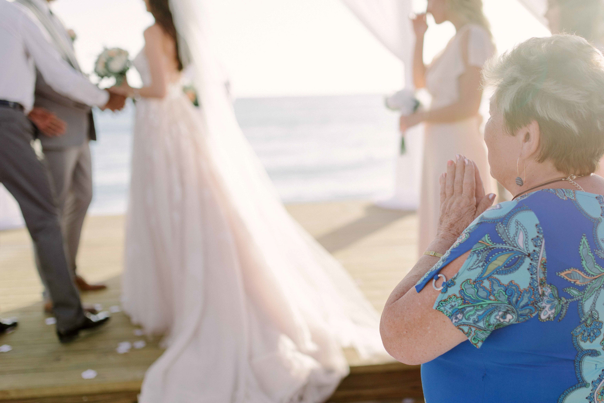 Bride and groom at the altar on the background of the sea and surrounded by guests.