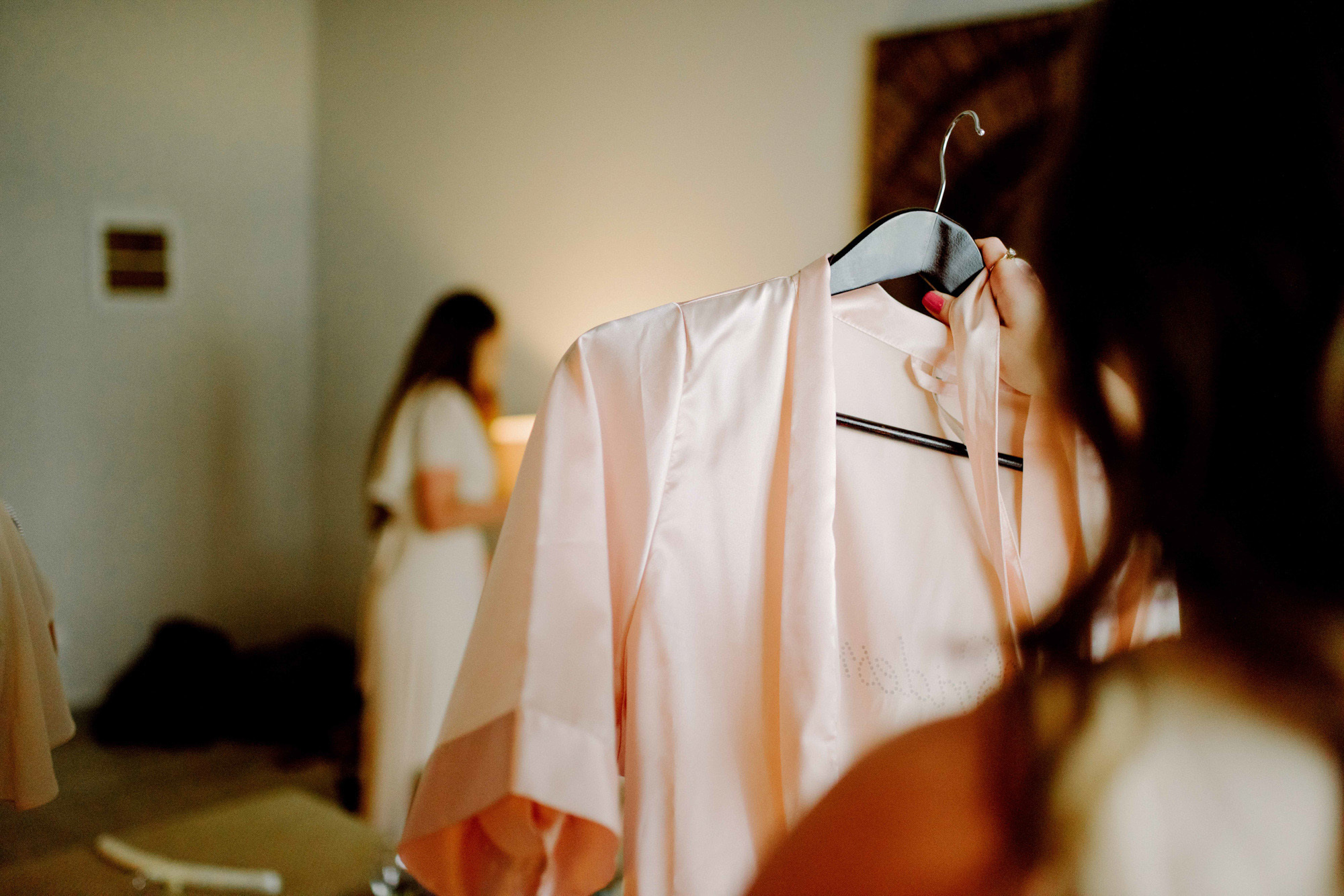 The bride hangs her robe on a hanger.