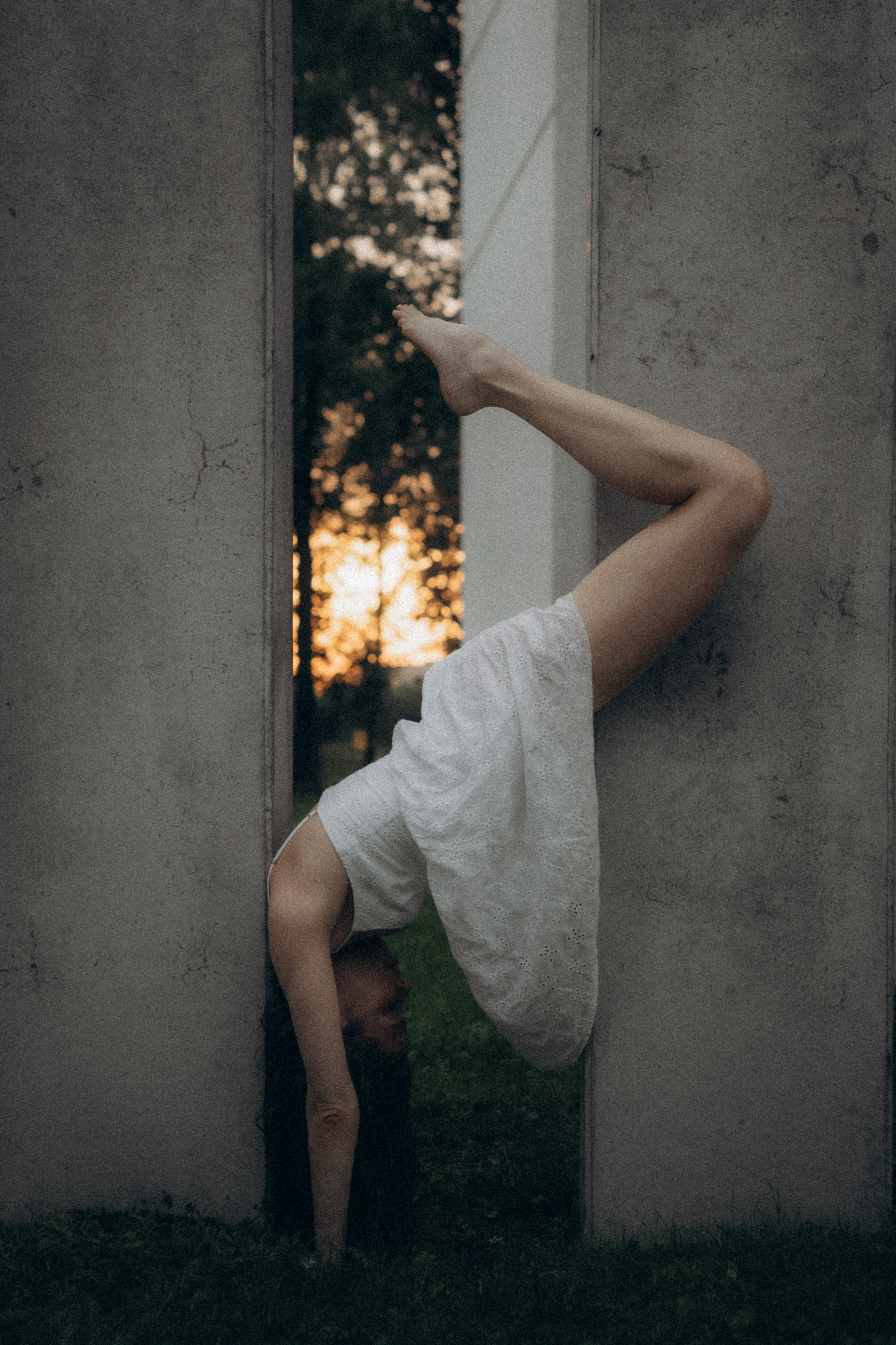 Fine art portrait of a woman positioned between concrete walls, evening light, Tallinn