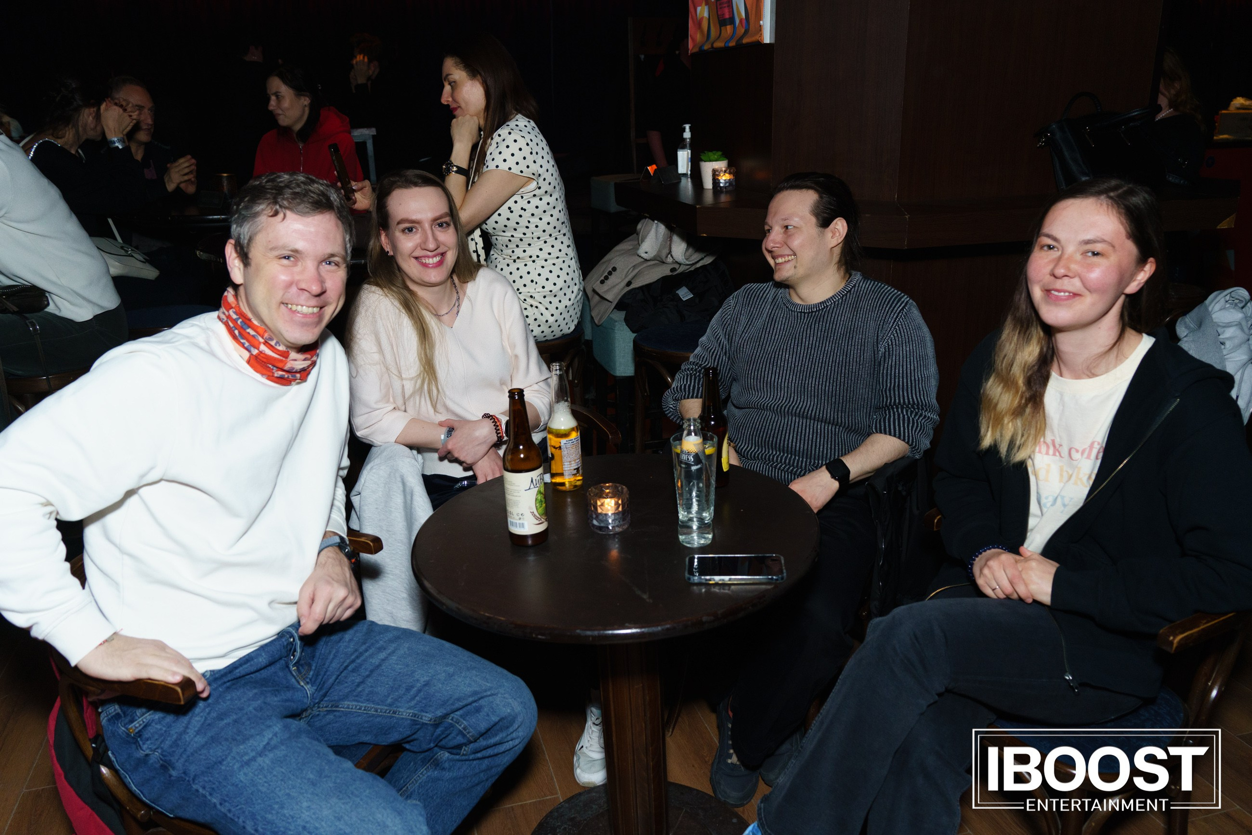 Group of concert guests smiling around a table at the Animal JazZ show in Sofia.