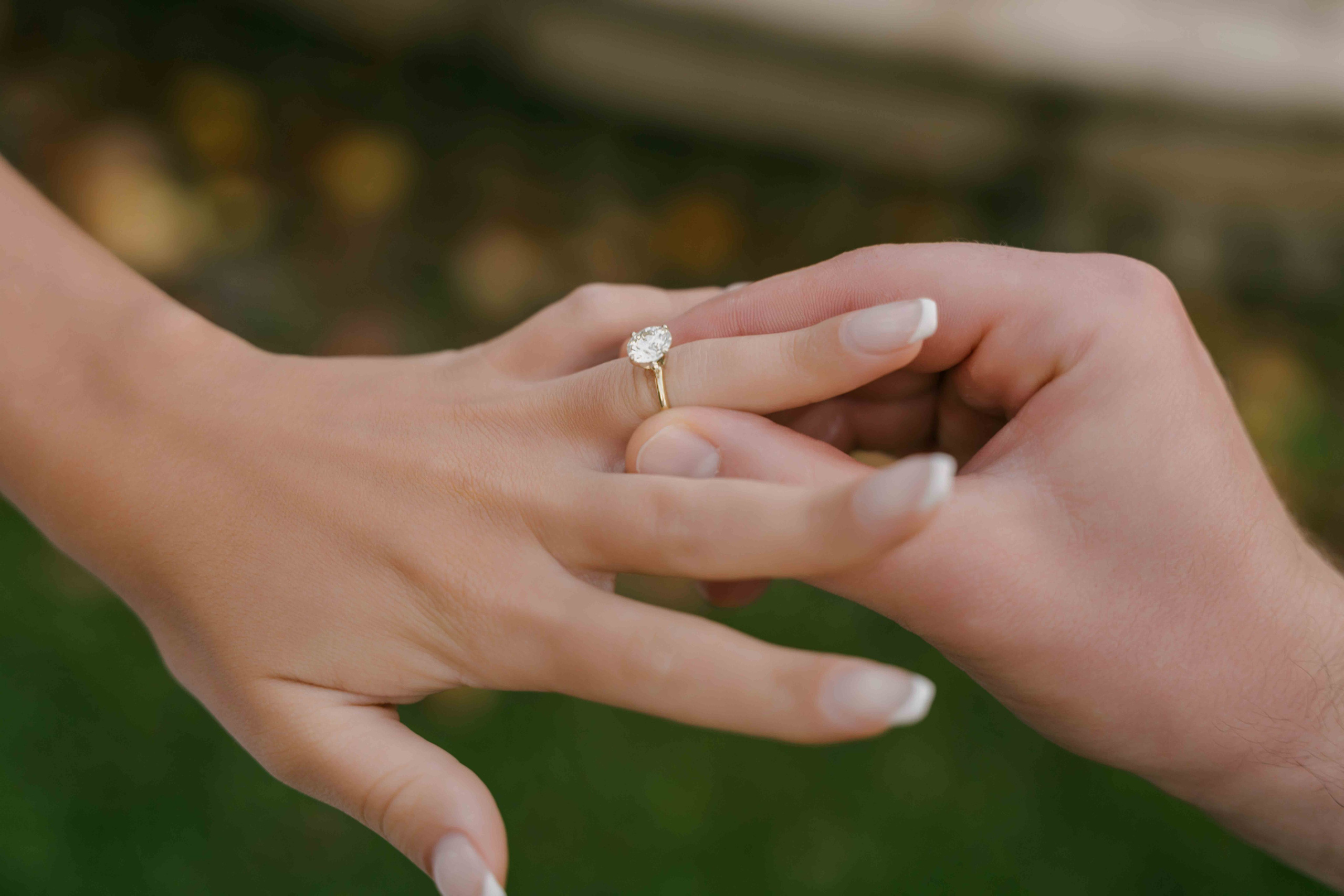 Close-up of engagement ring being placed on finger, proposal detail shot London