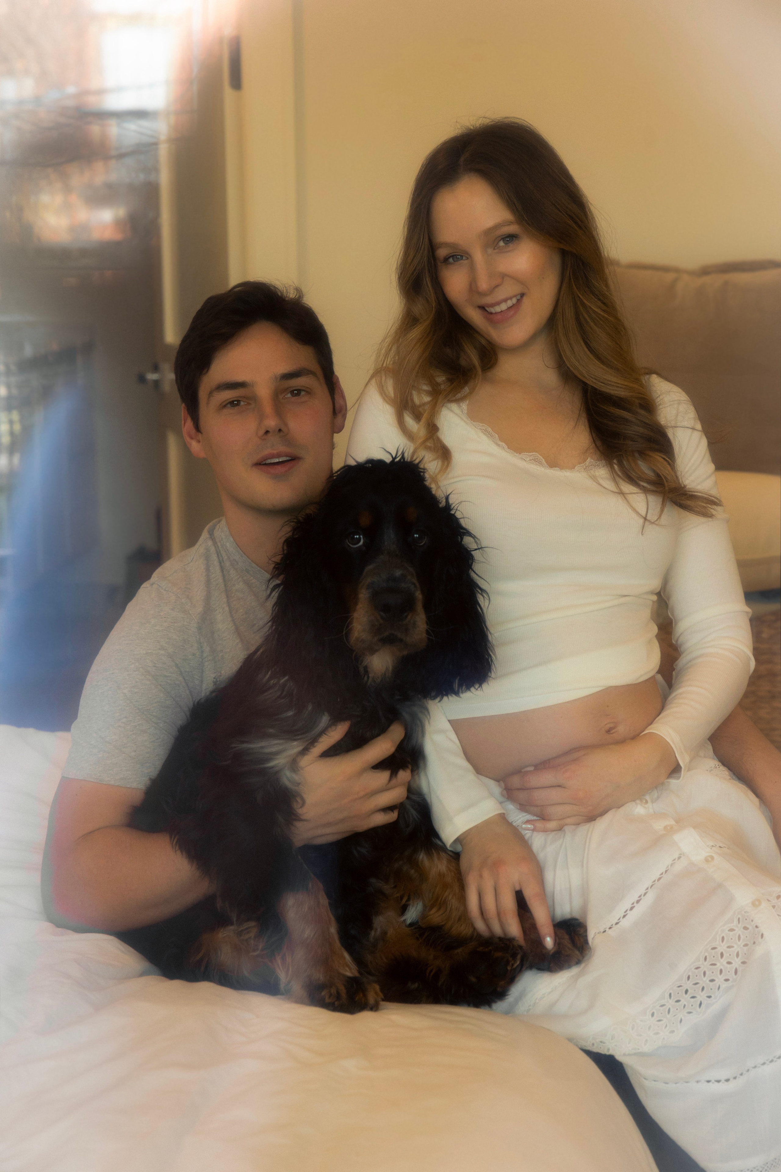 Family of three sharing a quiet moment together in a light-filled space