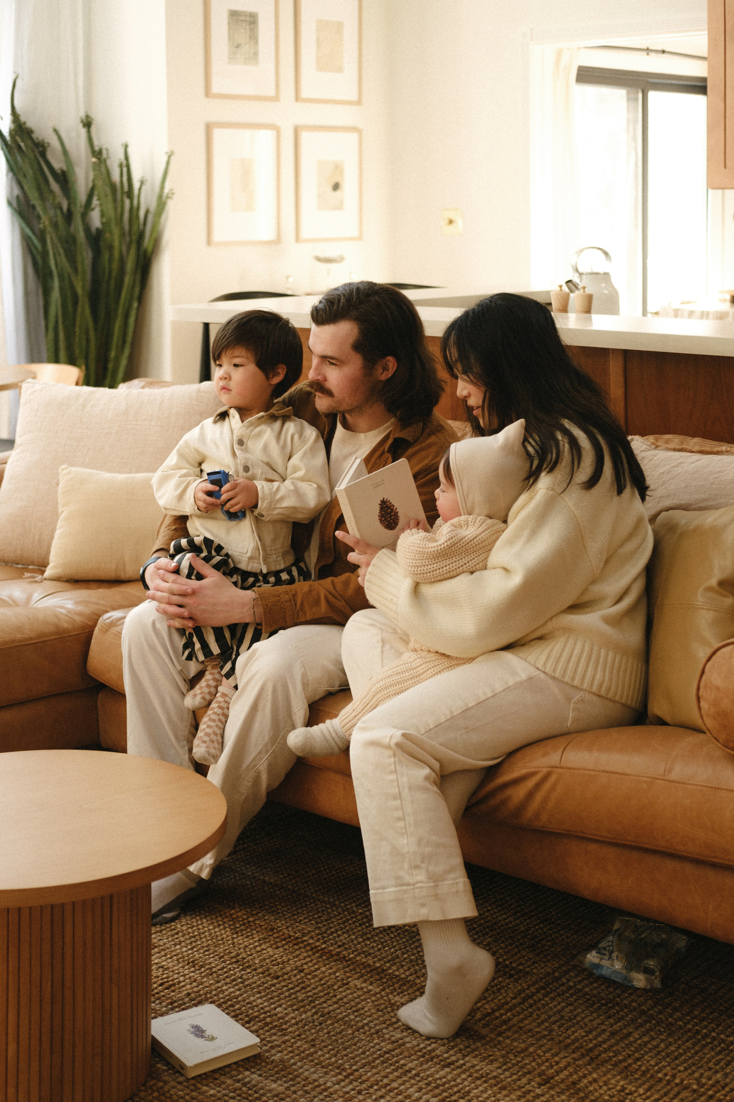 Family reading together on a cozy couch by the fireplace in Richmond, VA — soft light, snow outside, warmth inside.