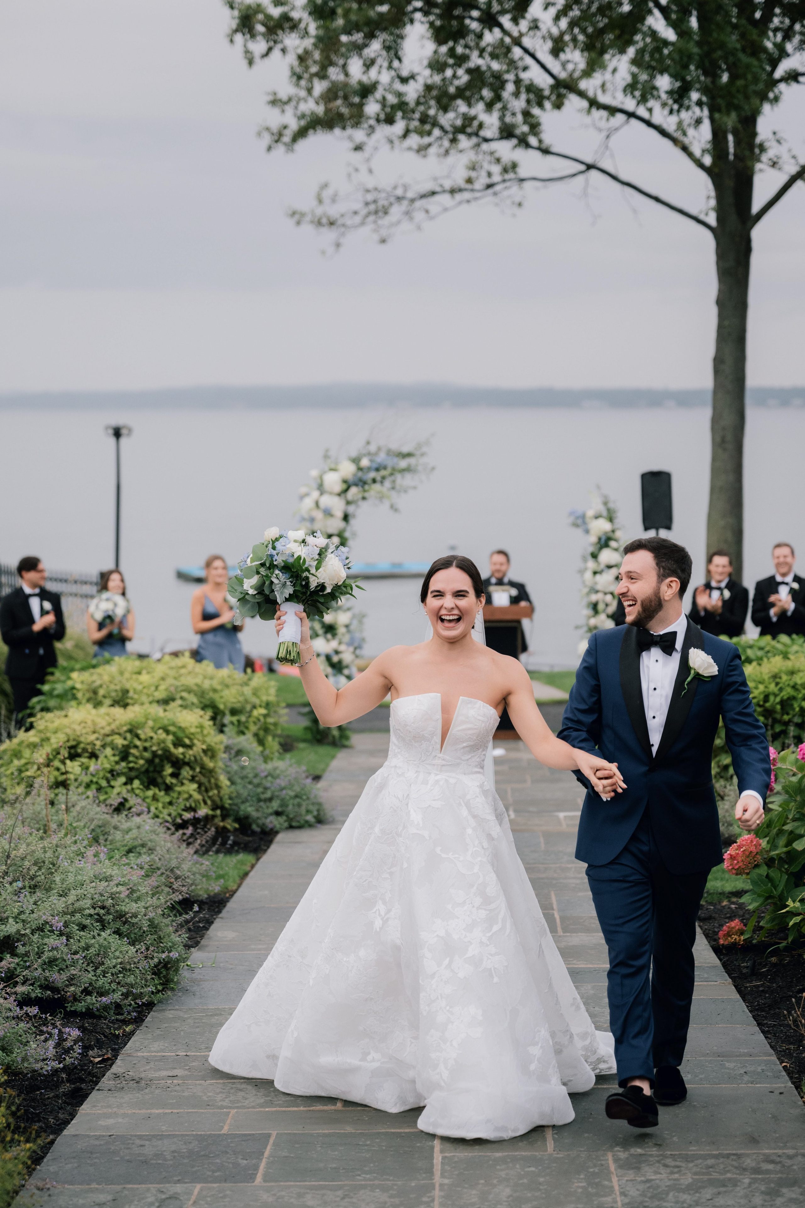a bride and groom walking down a path