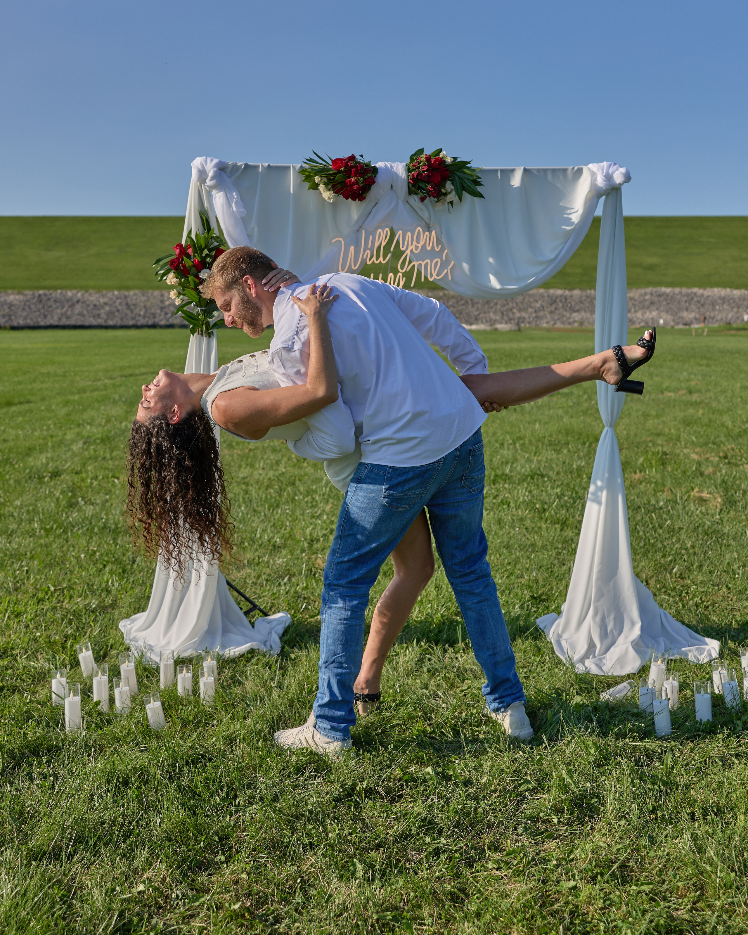 Dramatic dip kiss beneath the proposal arch at Alum Creek, Ohio
