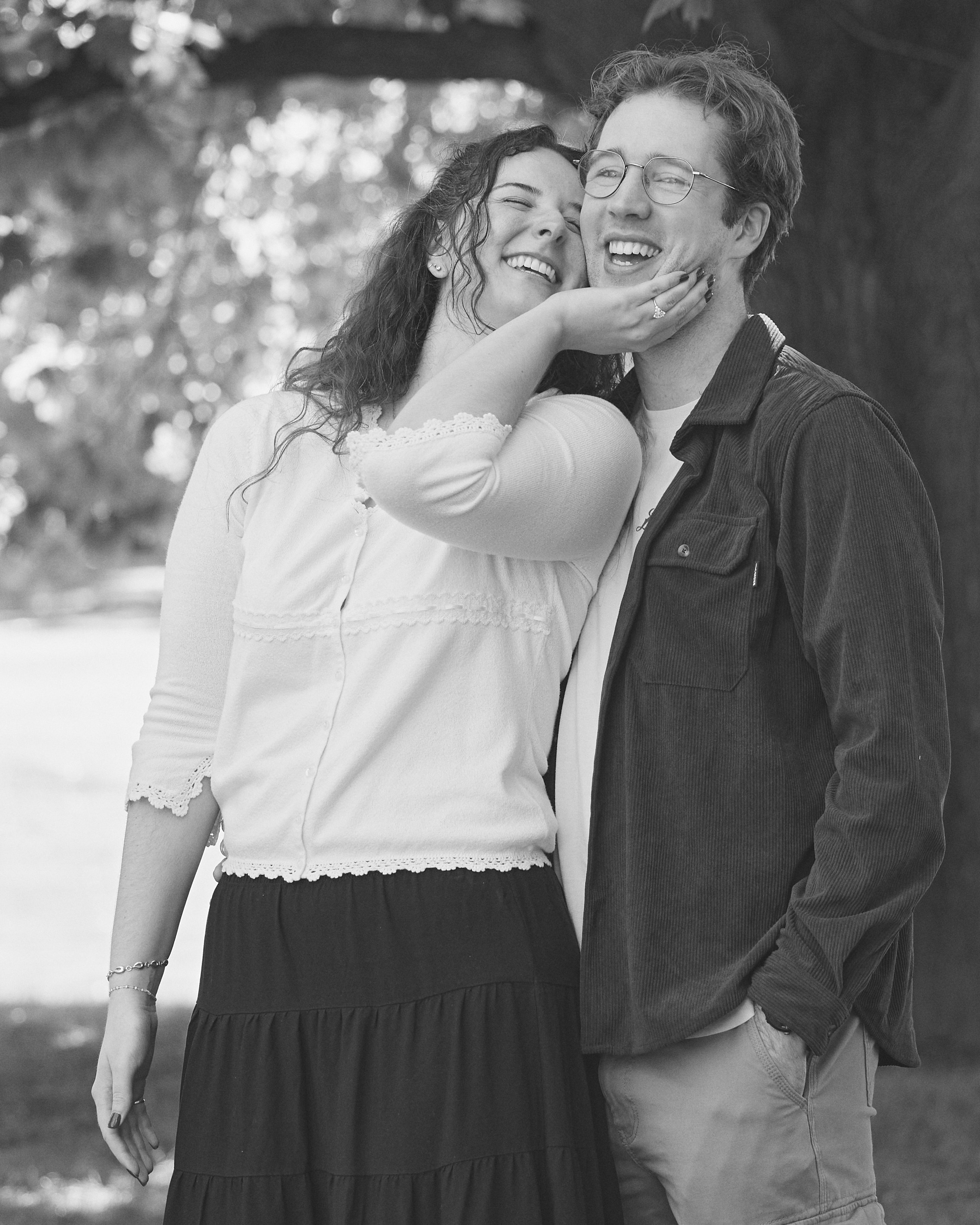 Black and white photo of a laughing couple embracing in a Columbus park