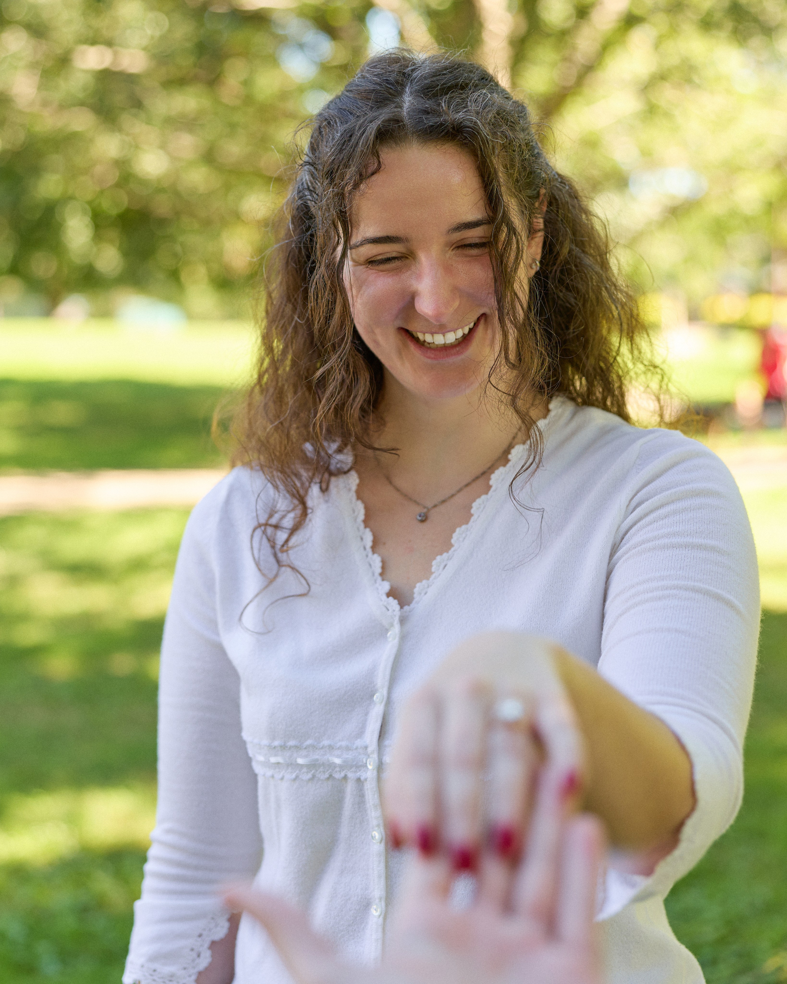 Smiling woman showing her engagement ring to the camera in a Columbus, Ohio park
