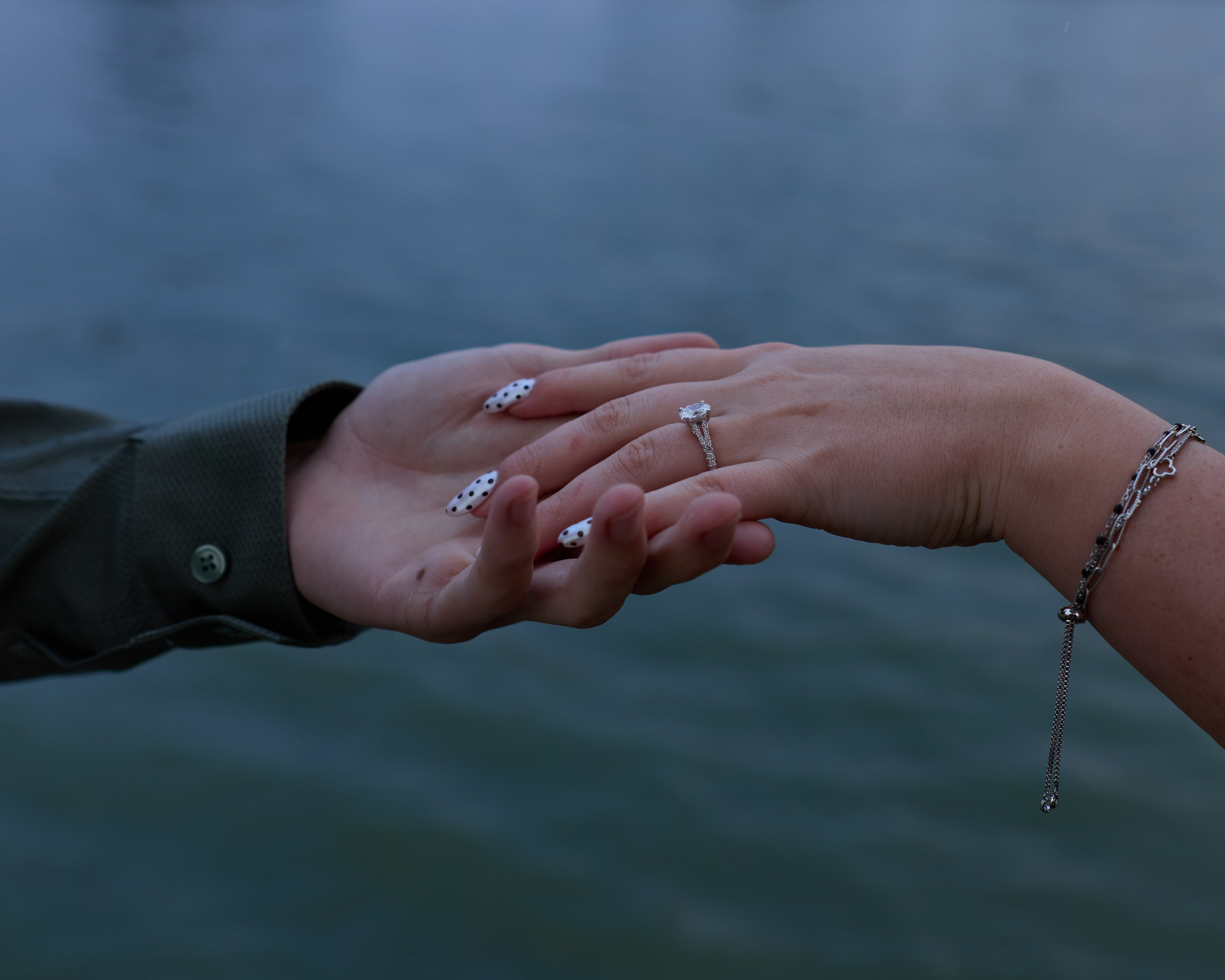 Close-up of hands with the new engagement ring over the water at Buckeye Lake, Ohio