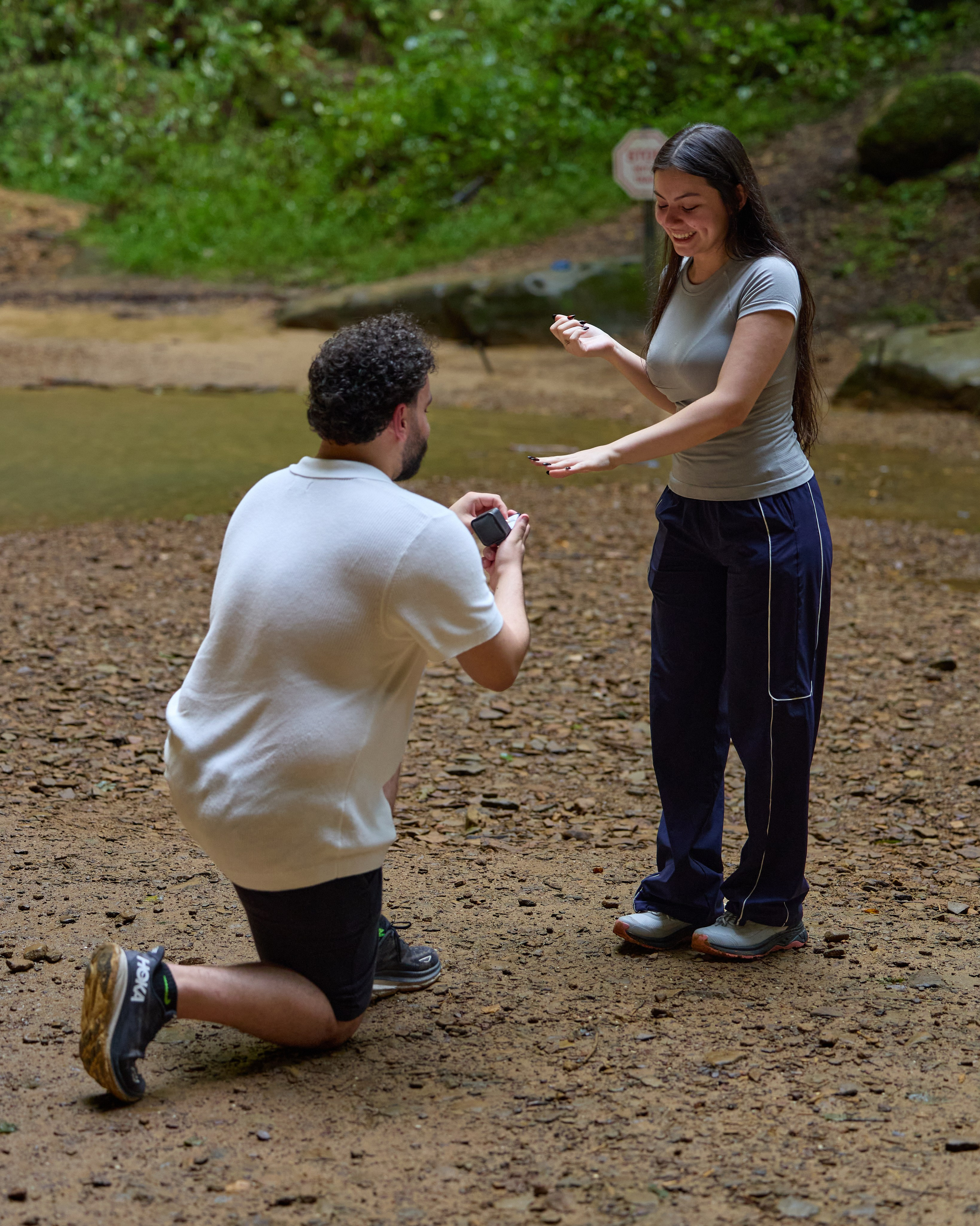 Kneeling proposal on rocky ground by a stream in Hocking Hills, Ohio