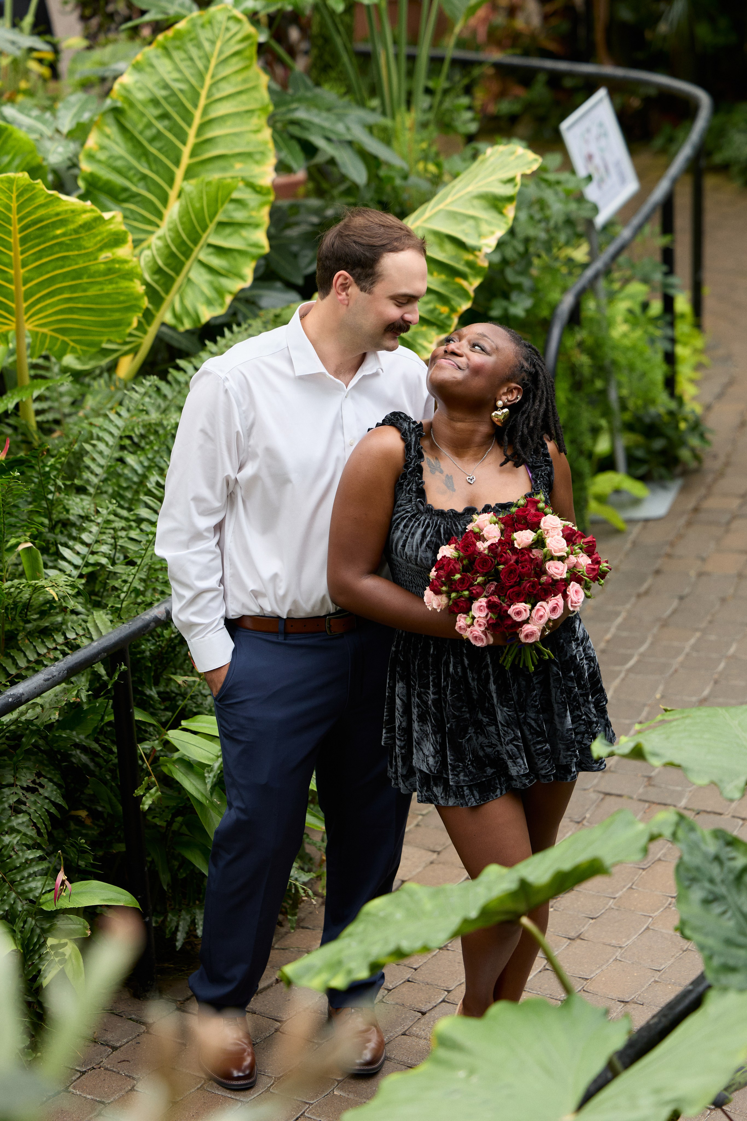 Engaged couple portrait among giant tropical leaves at Franklin Park Conservatory in Columbus, Ohio