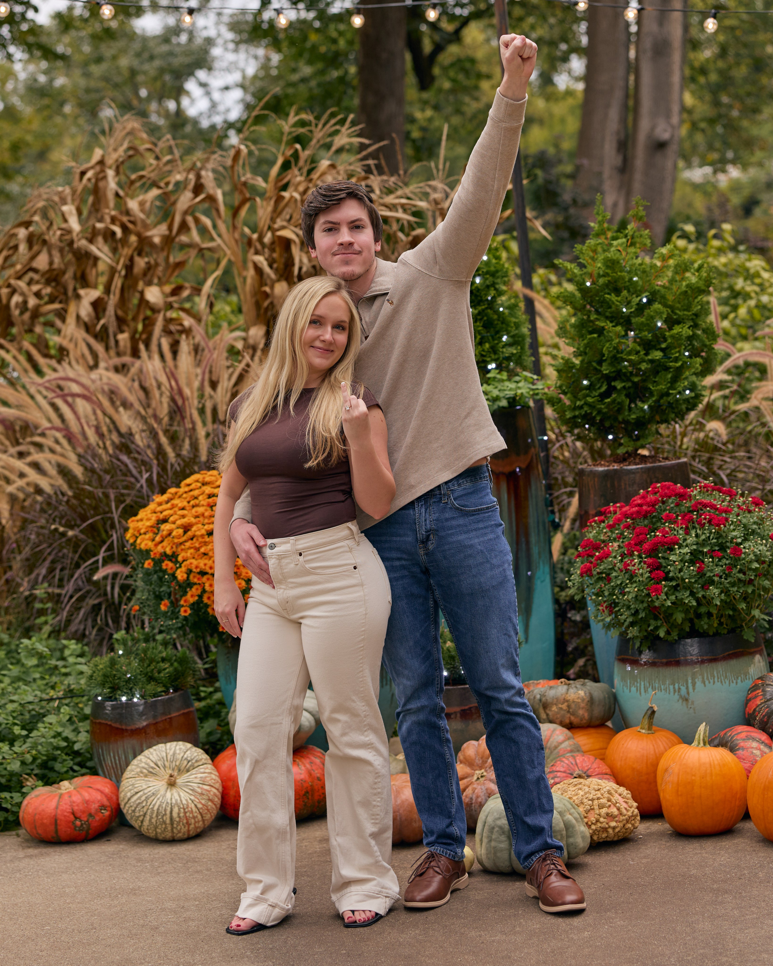 Couple posing with pumpkins at the fall display inside Franklin Park Conservatory in Columbus, Ohio