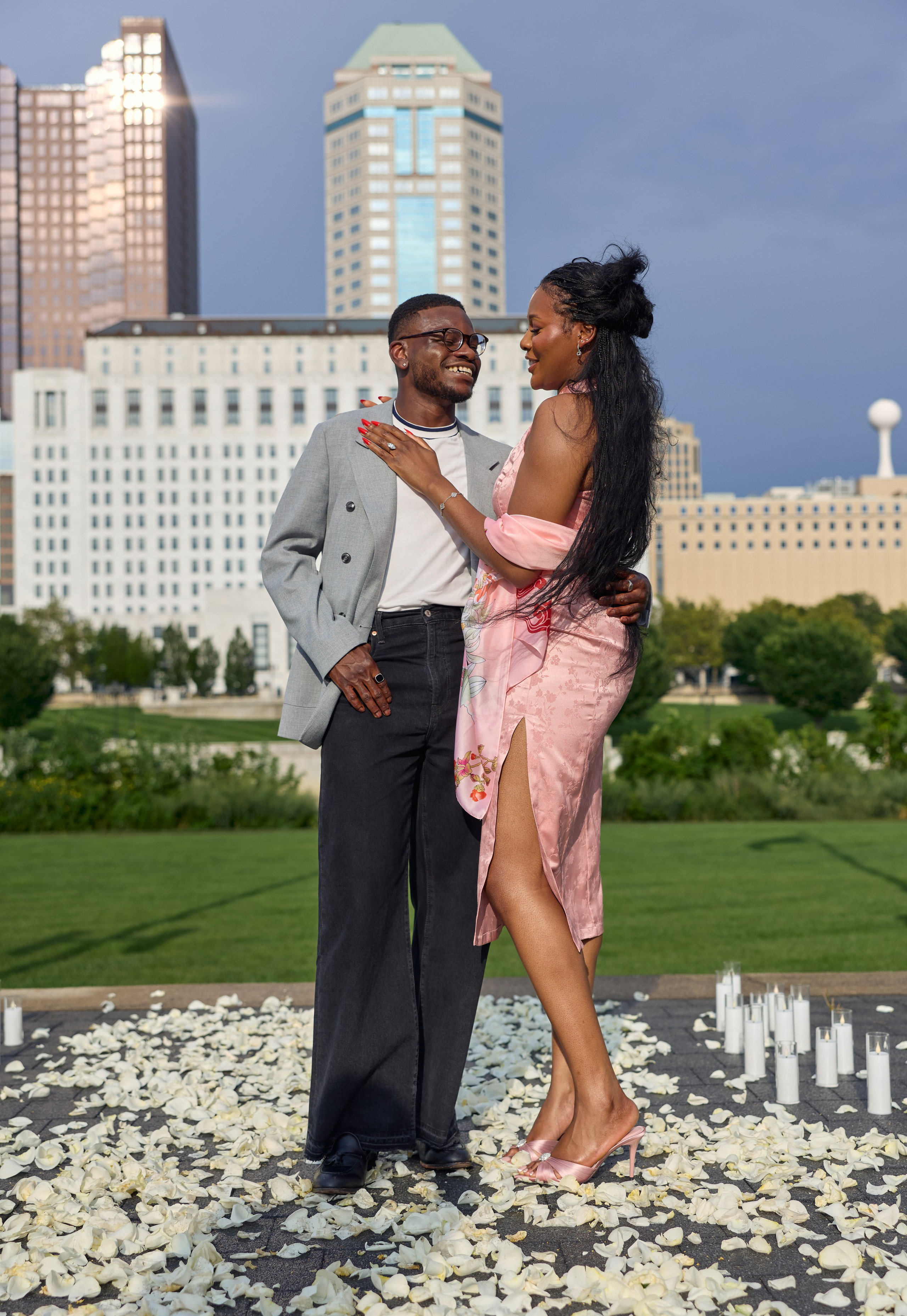 Groom lifting his fiancée with the downtown Columbus skyline behind