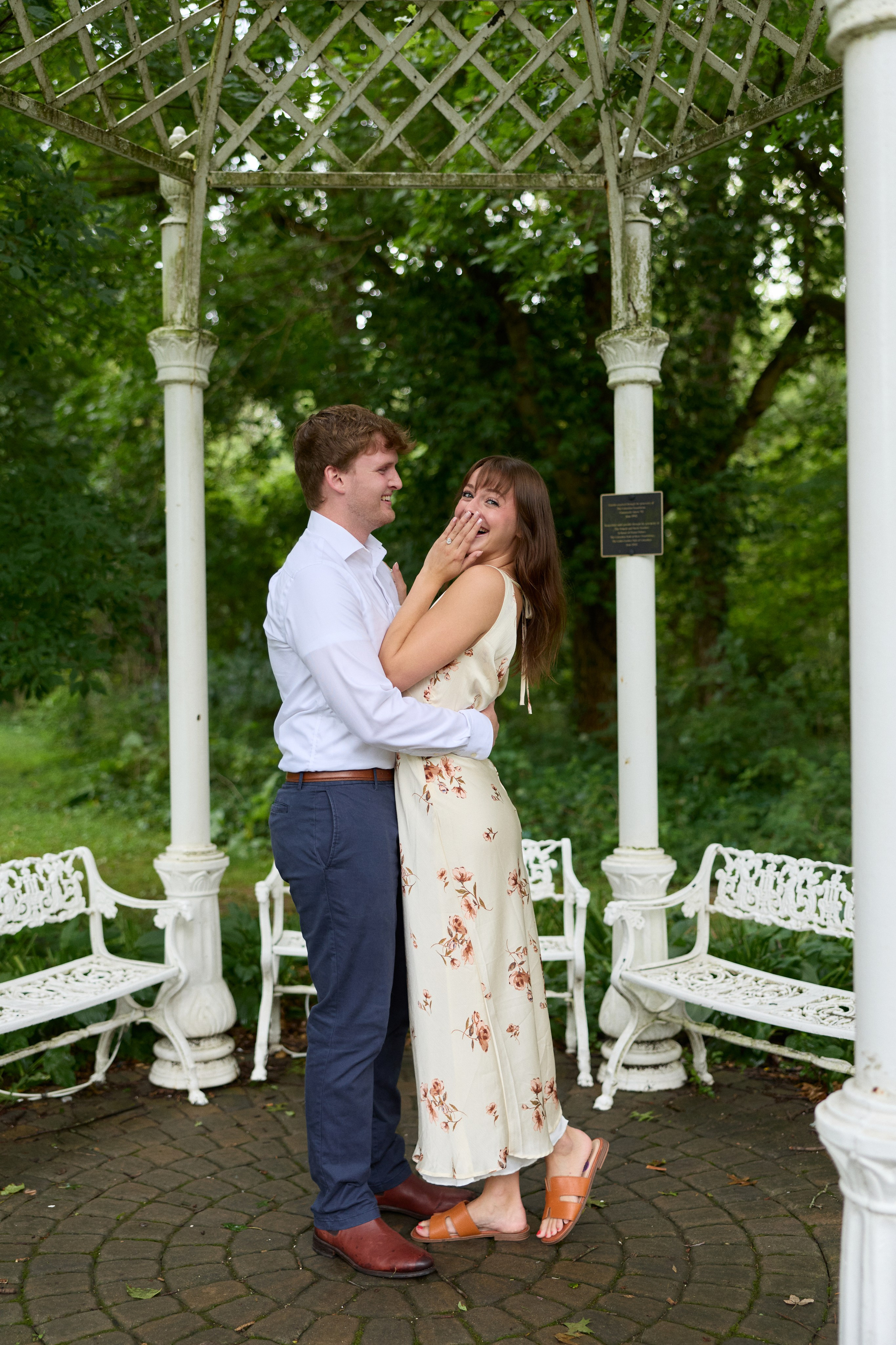 Newly engaged couple kissing under the white gazebo at the Park of Roses in Columbus, Ohio