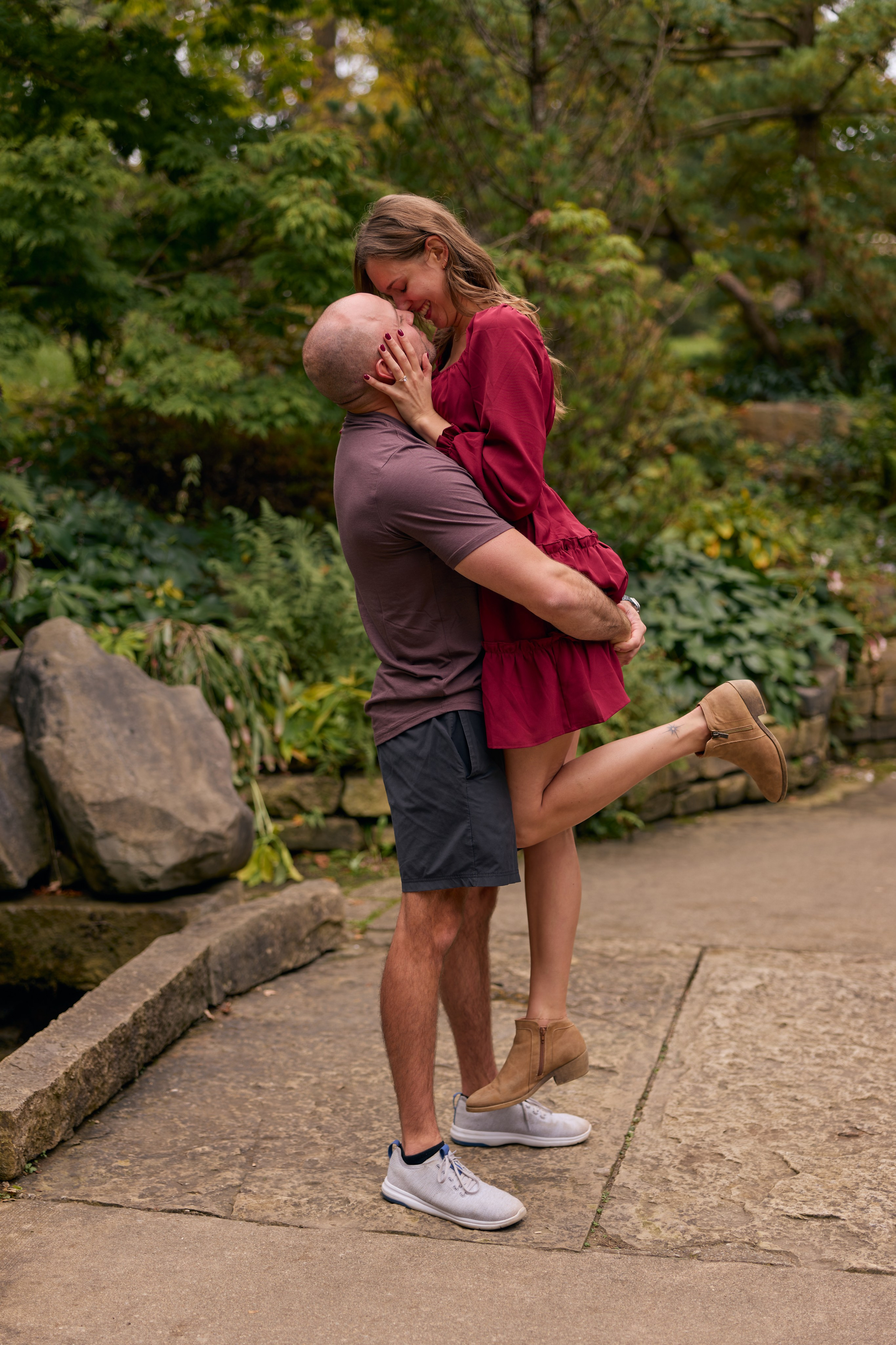 Dramatic dip kiss on a stone bridge over the waterfall at Inniswood Metro Gardens, Ohio