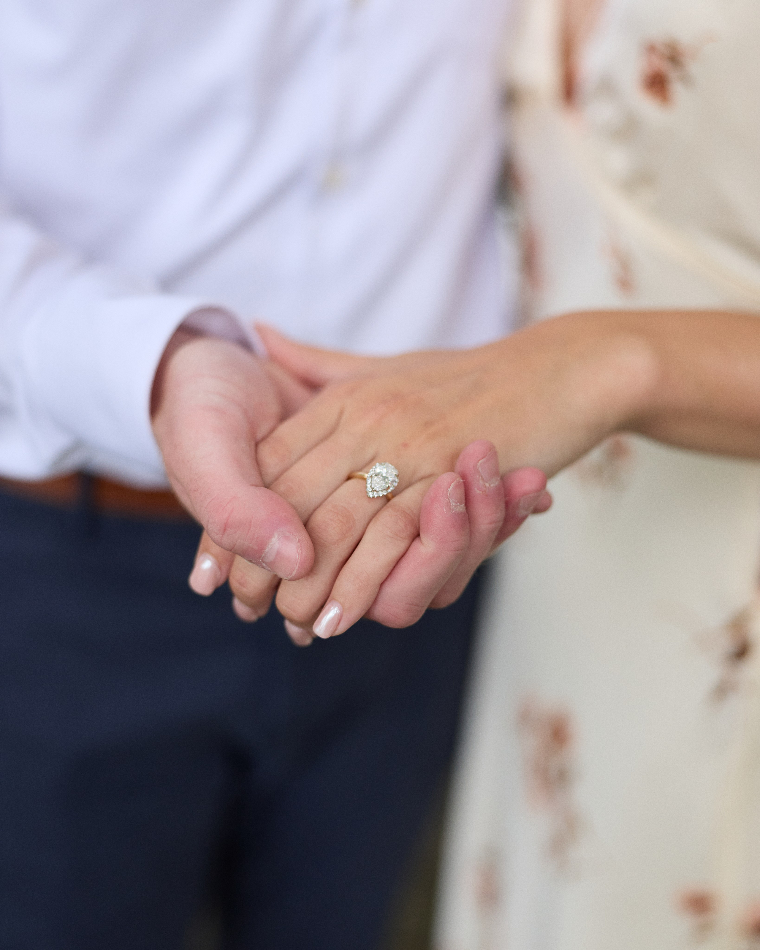 Detailed close-up of intertwined hands with an engagement ring at the Park of Roses in Columbus, Ohio