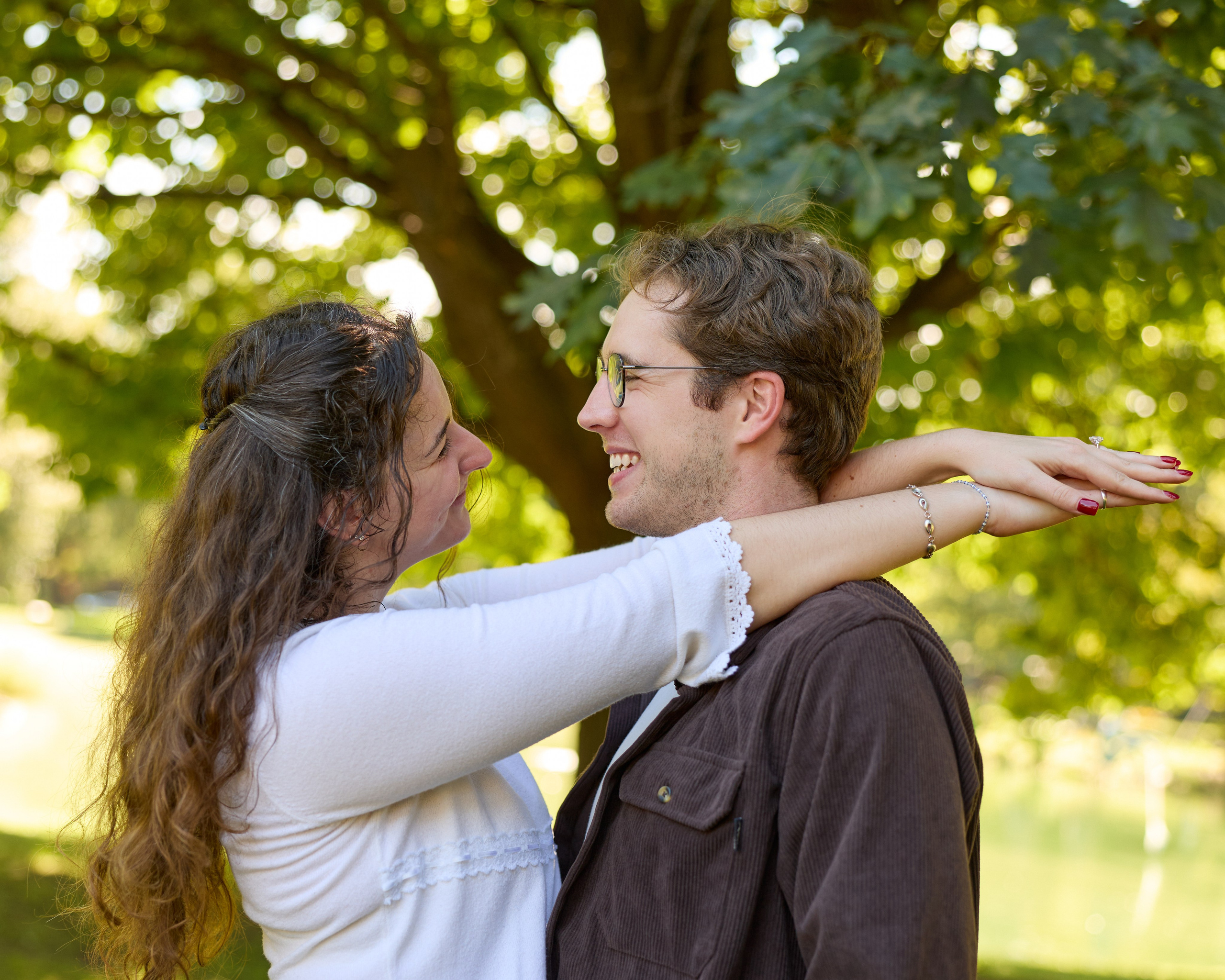 Tender embrace in a sunlit park after a Columbus, Ohio proposal
