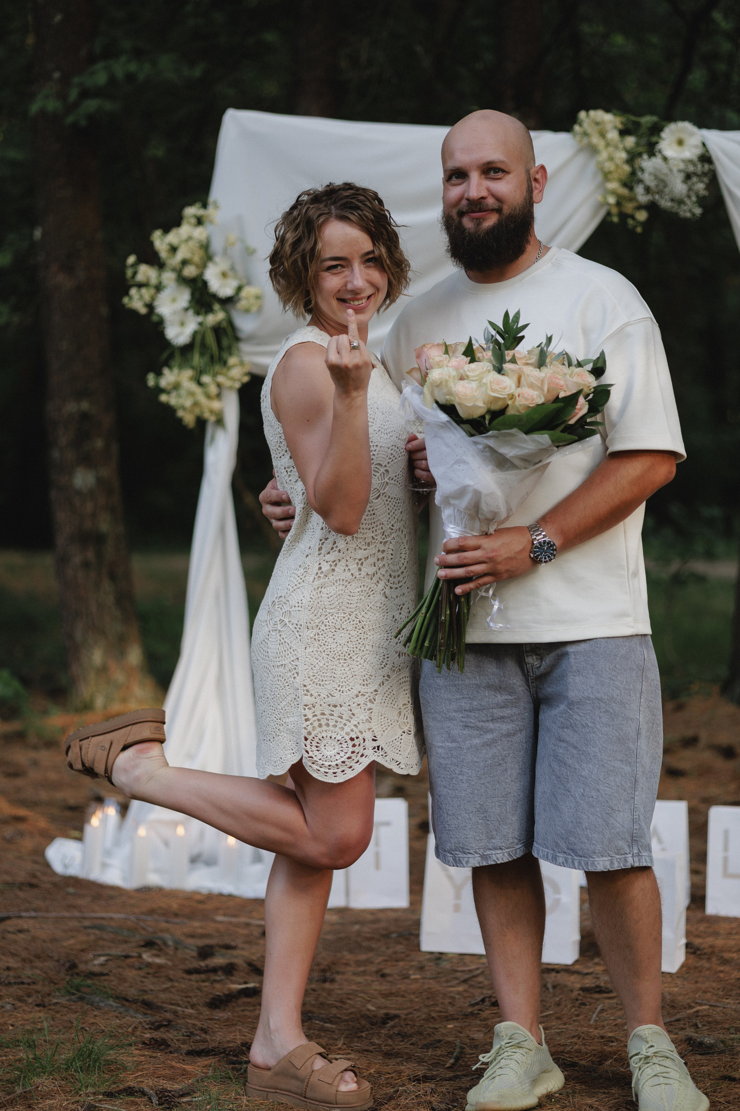 Playful kick-up pose with flowers under the arch near Columbus, Ohio