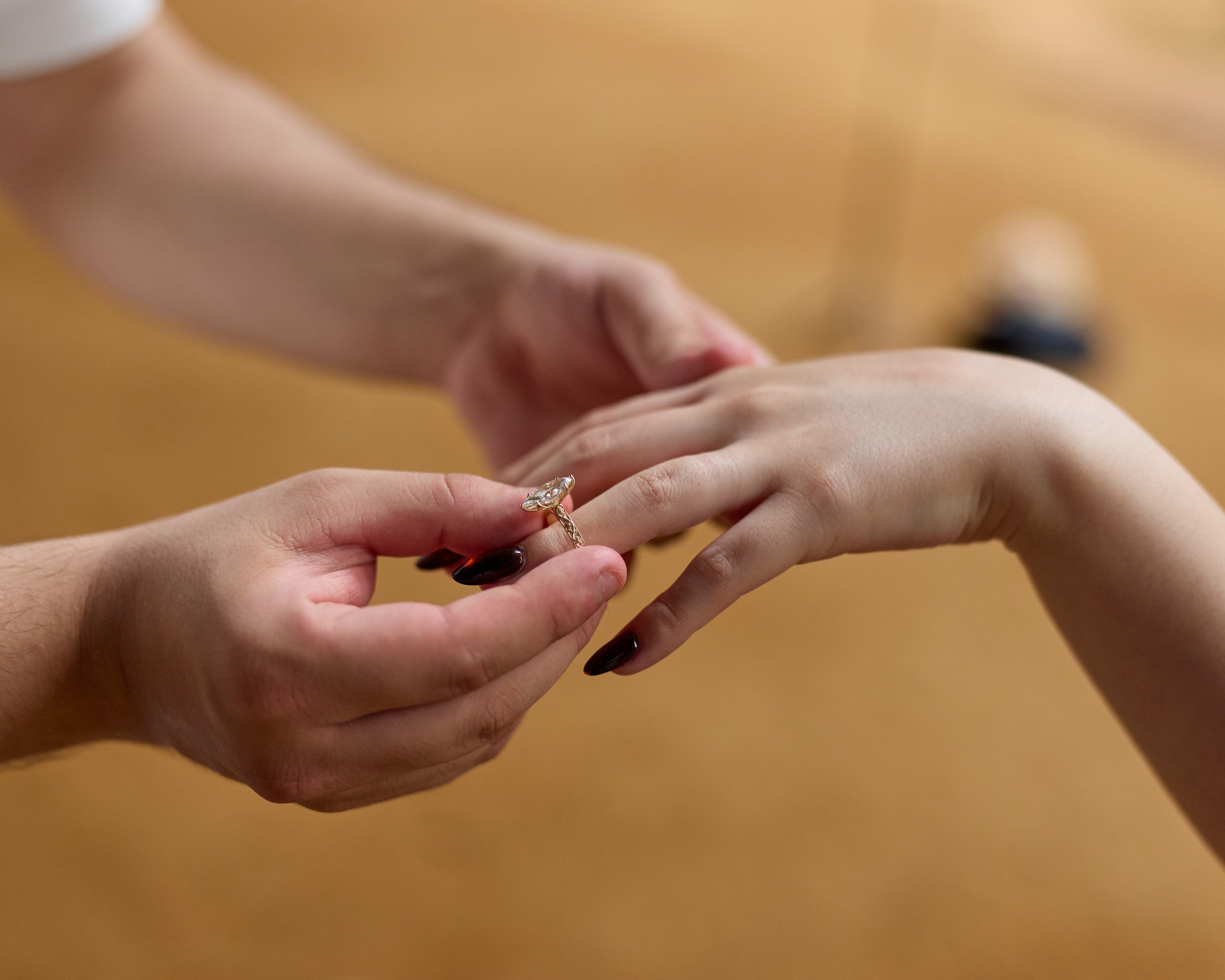 Close-up of an engagement ring being slipped onto her finger outdoors in Ohio