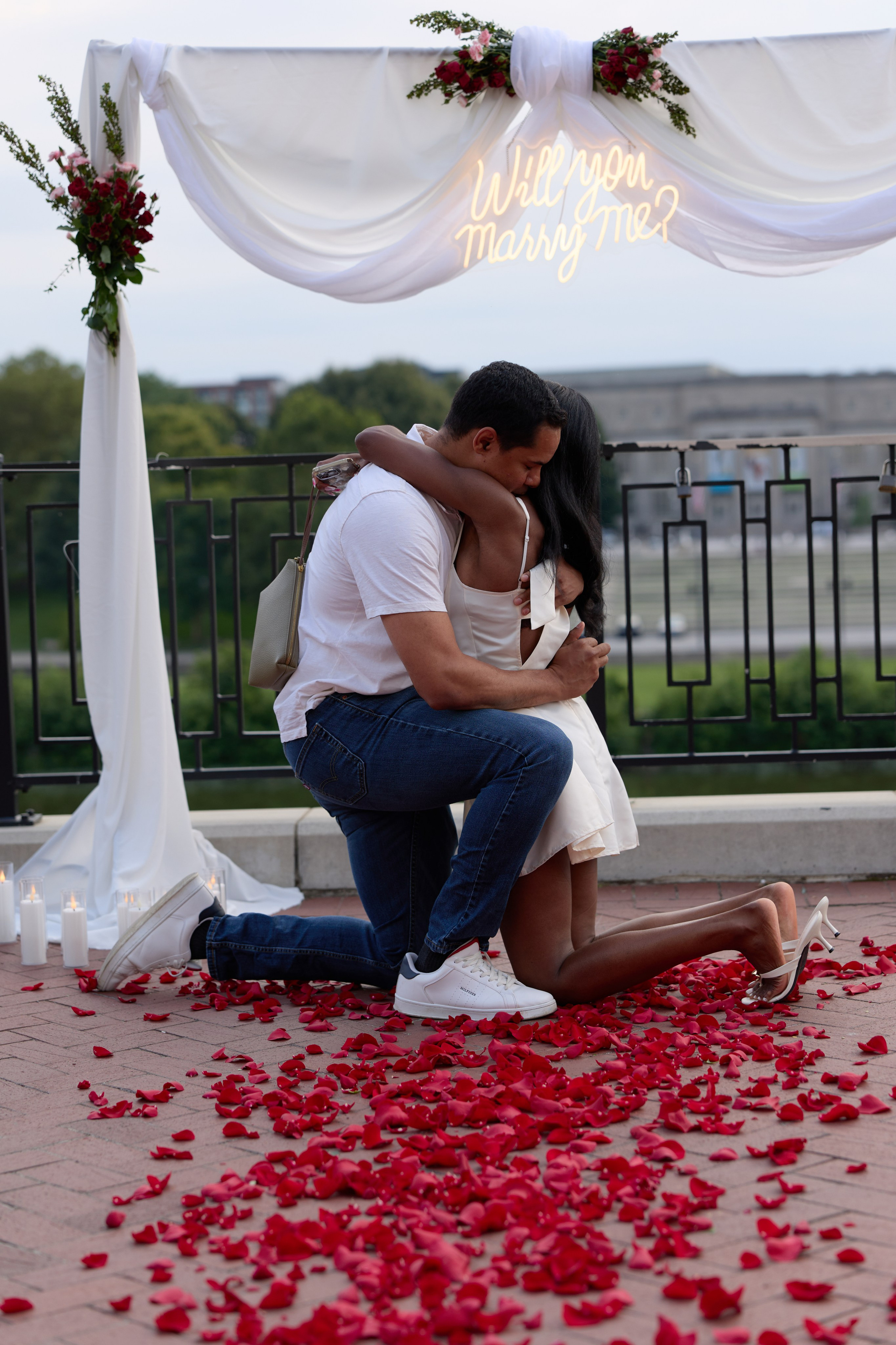 Romantic kiss under the proposal arch surrounded by rose petals in Columbus, Ohio