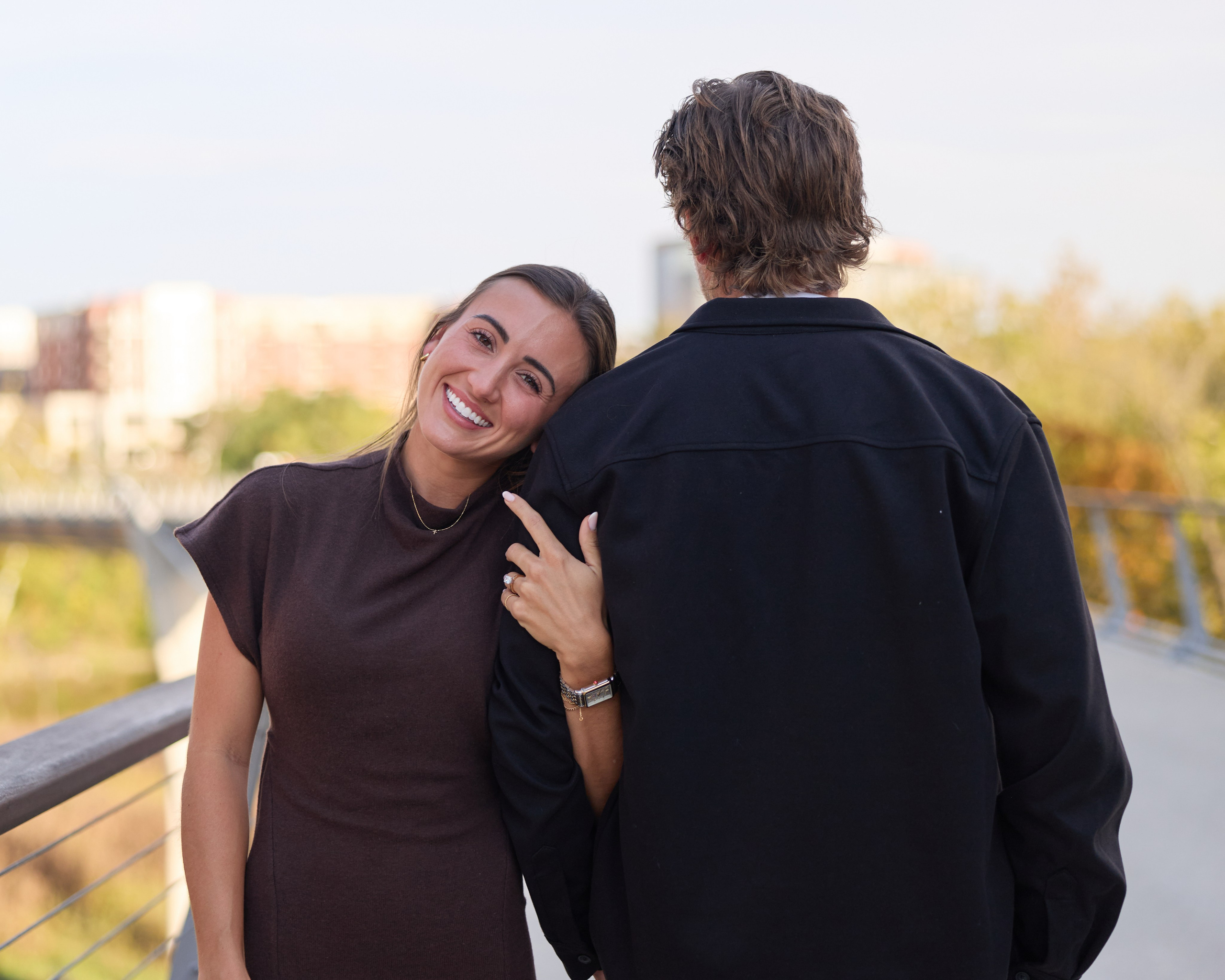 Couple from behind on the bridge, her smiling back at the camera in Dublin, Ohio