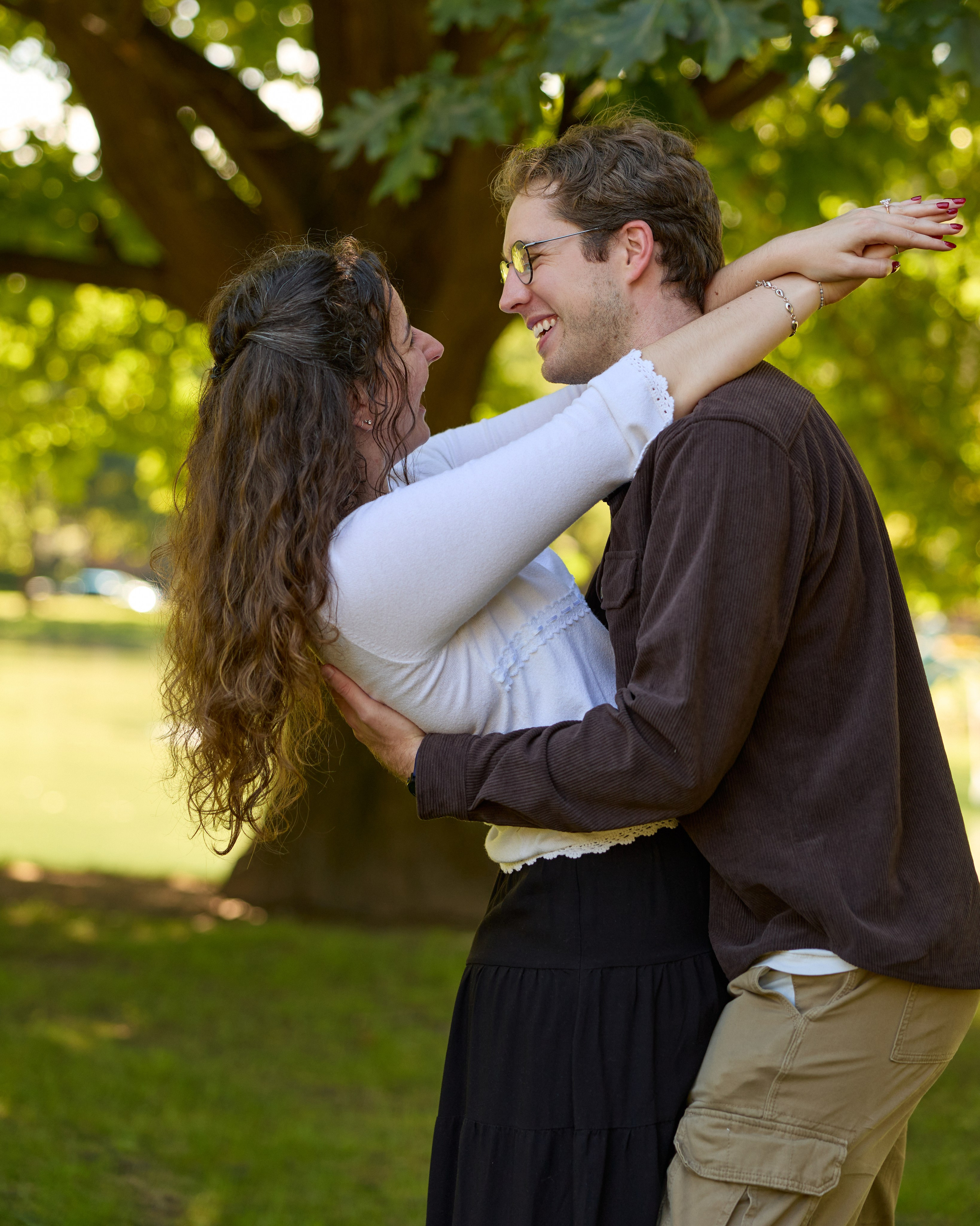 Laughing couple hugging in a green Columbus, Ohio park