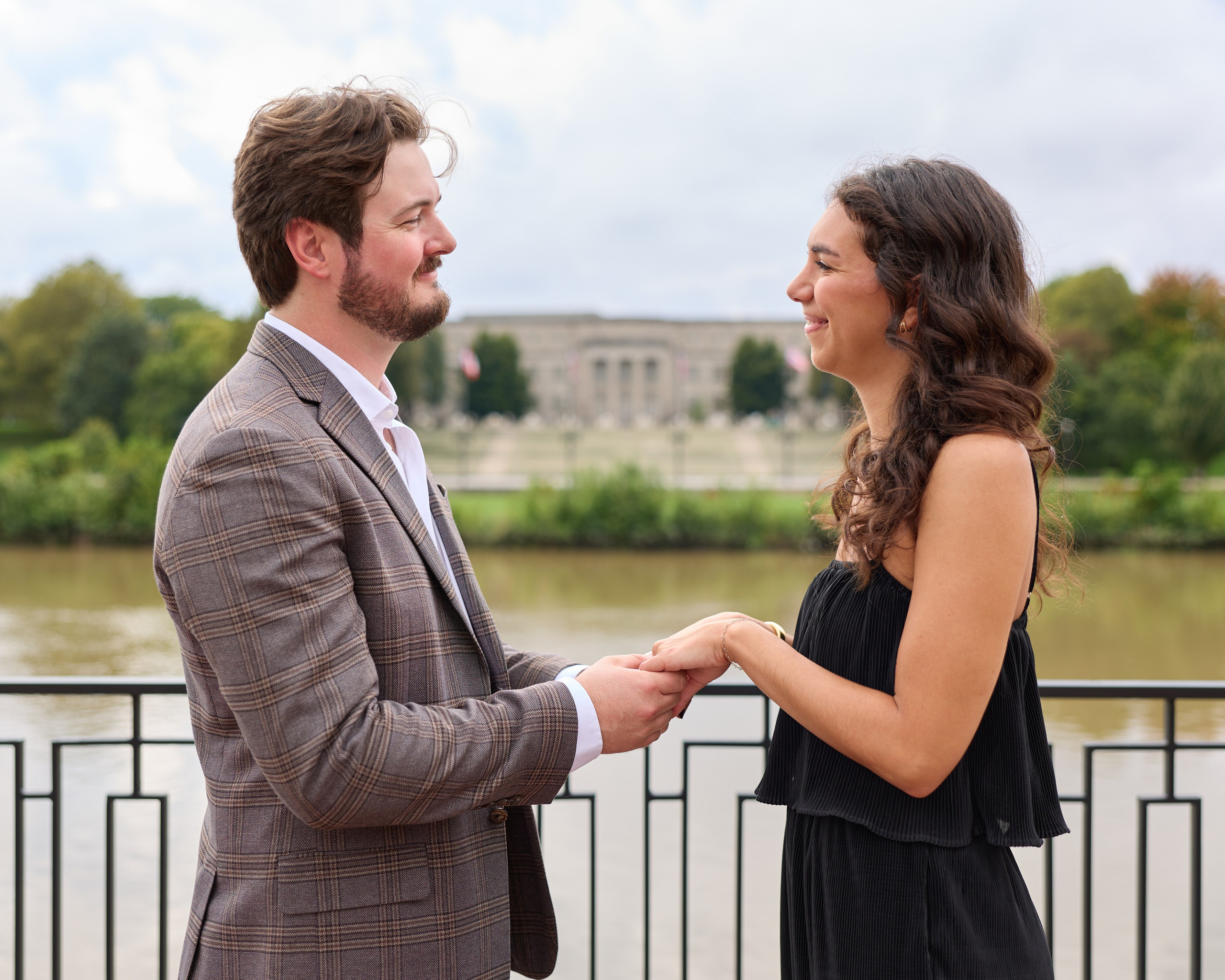 Couple holding hands and gazing at each other with downtown Columbus behind them