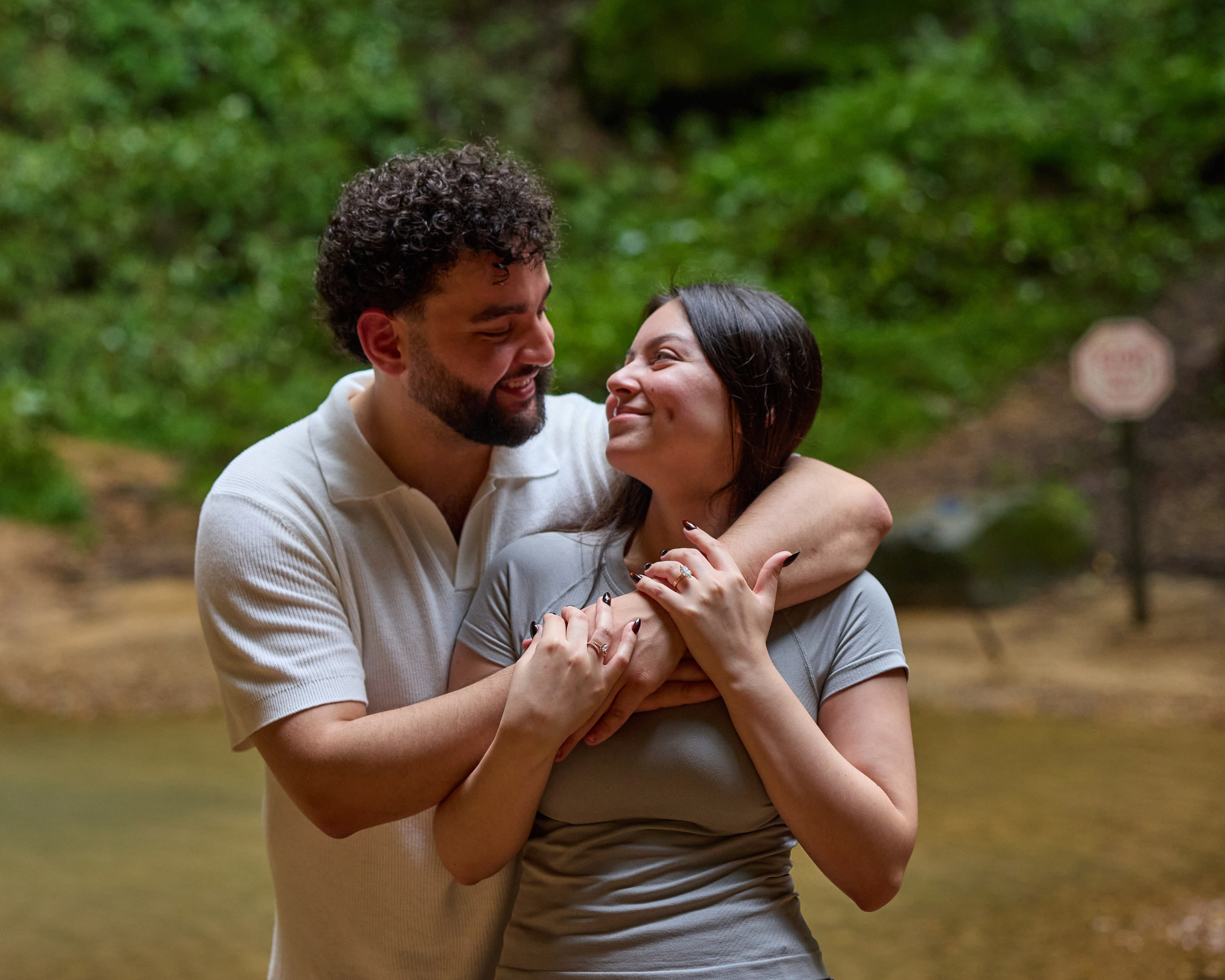Happy couple embracing with lush green forest behind them in Hocking Hills, Ohio