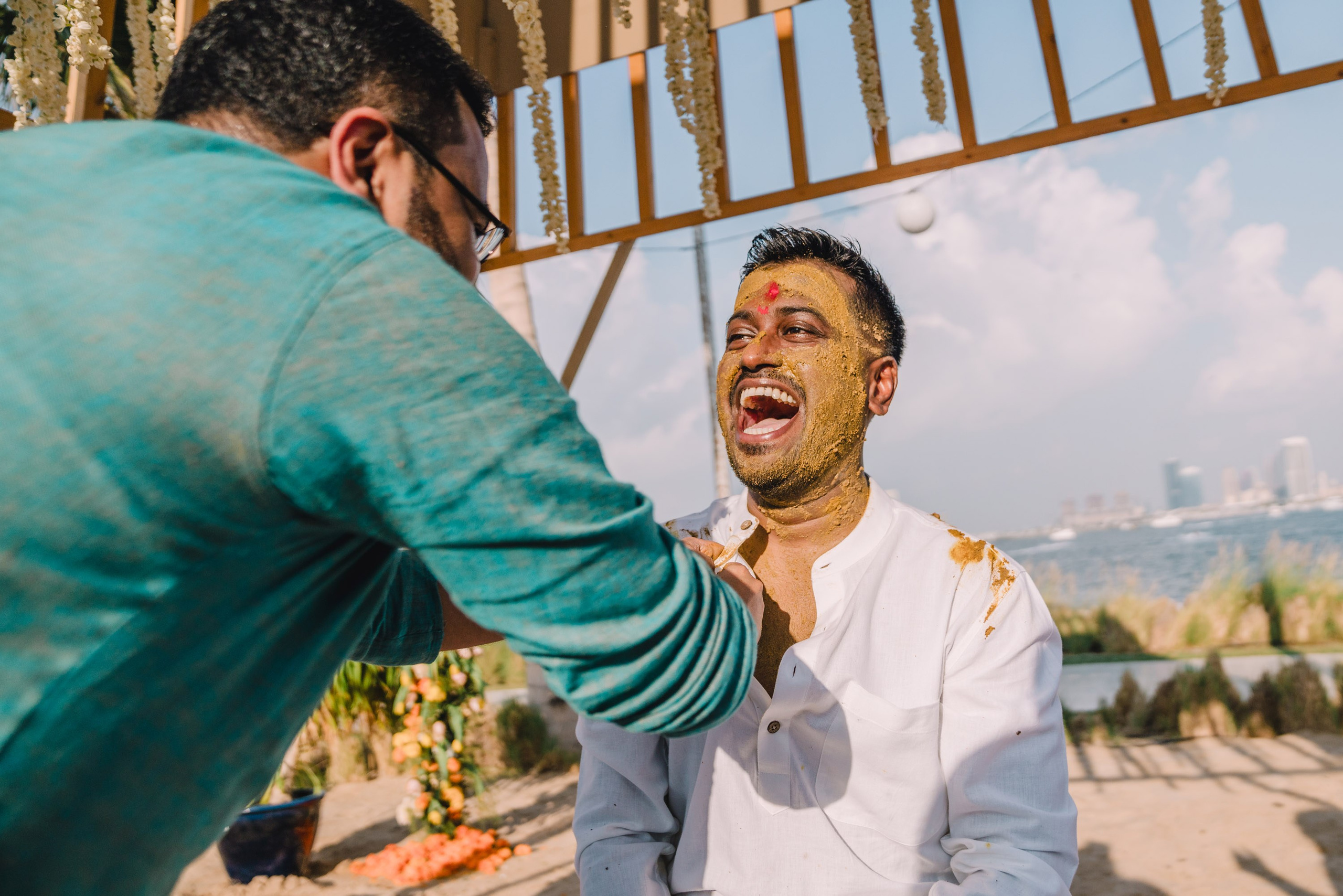 groom is laughing as his friend is touching him in a funny way