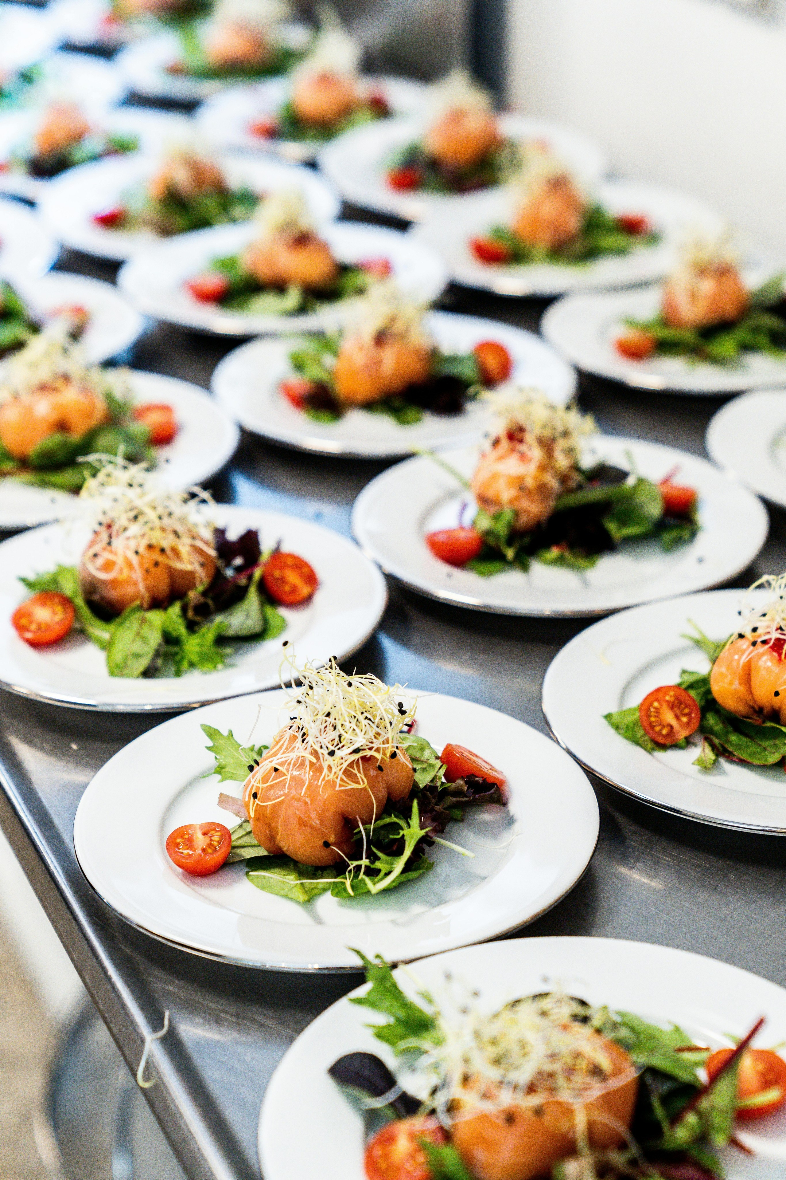 Professional event food photography showing catering table with multiple plated dishes by Jay Soundo