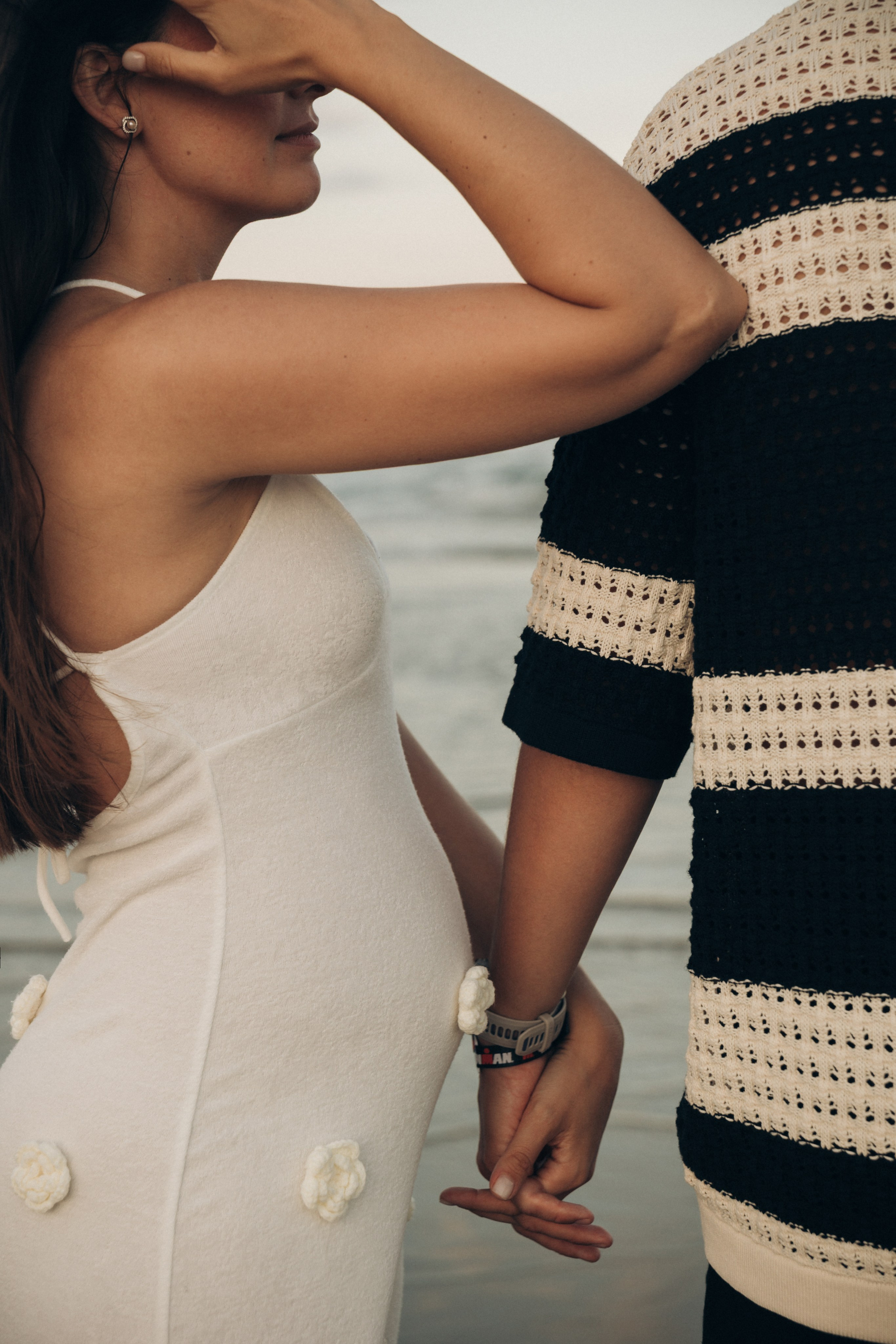 Dettagli di un servizio fotografico maternity a Rimini — mani della coppia e pancione