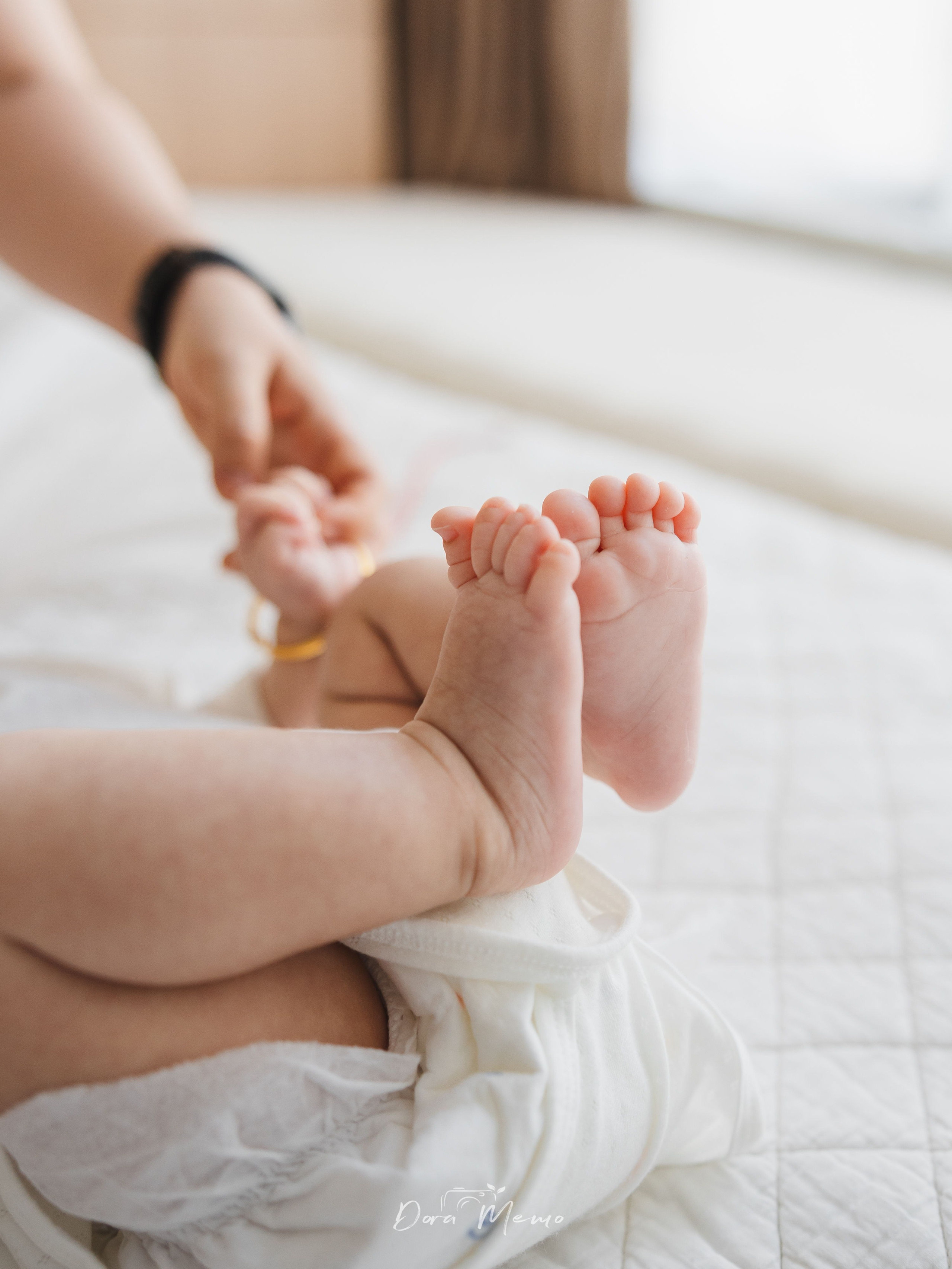 A close-up of a baby's tiny feet, adding a soft detail to the 100-day family story.