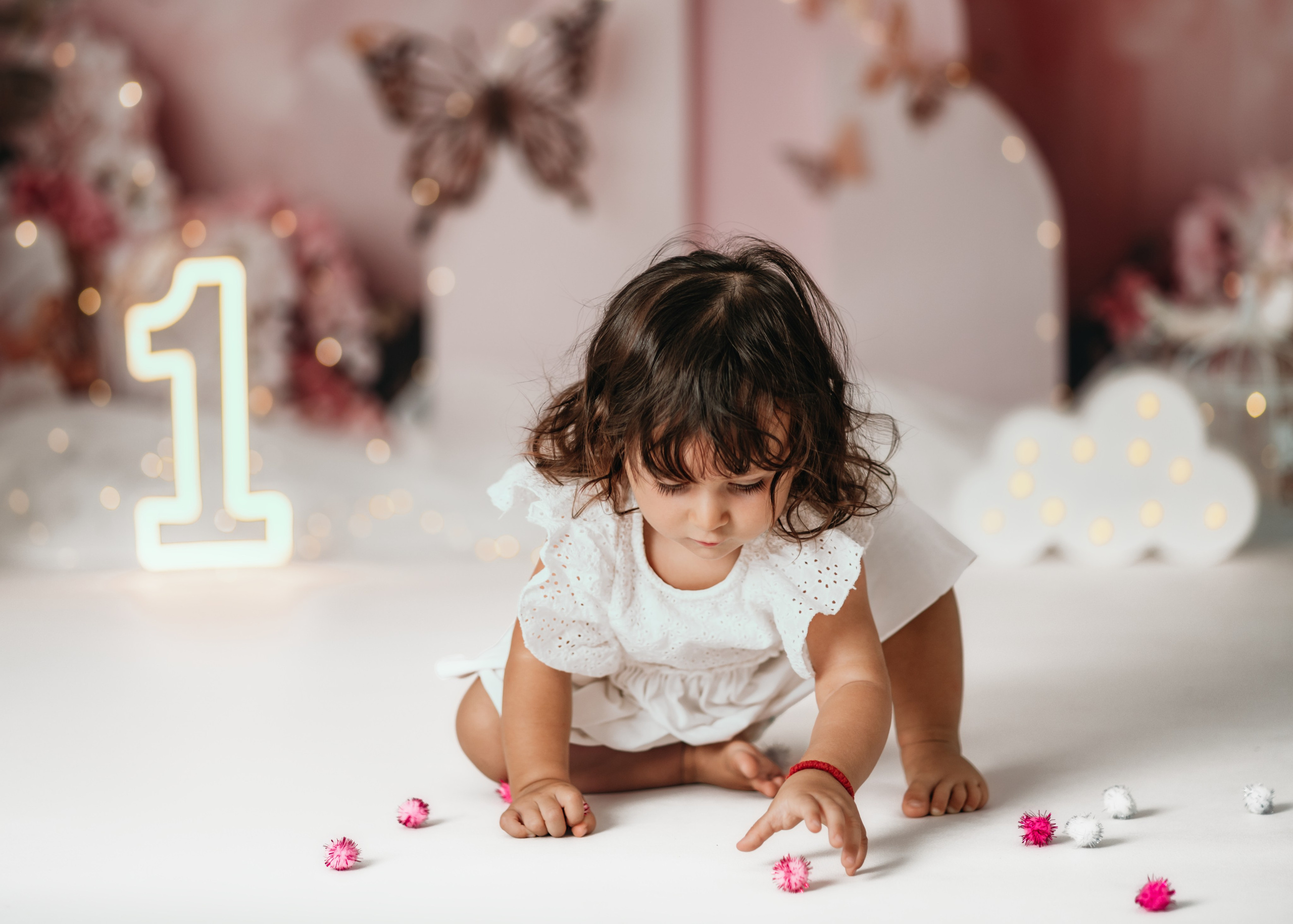 Prvi rođendan u Beogradu – cake smash fotografisanje u roze scenografiji sa tortom i zlatnim leptiricima