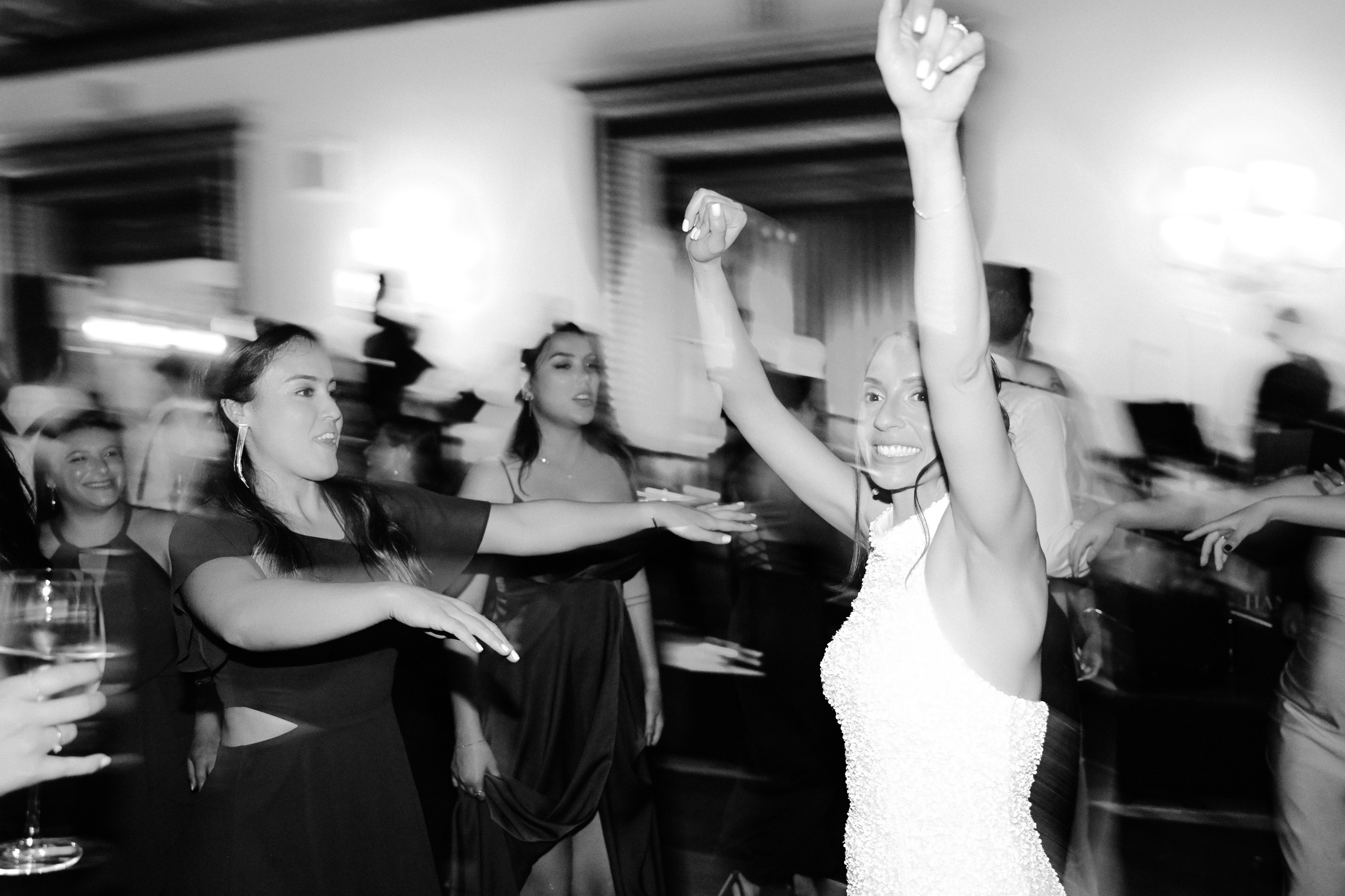 a bride dancing with her friends at a wedding