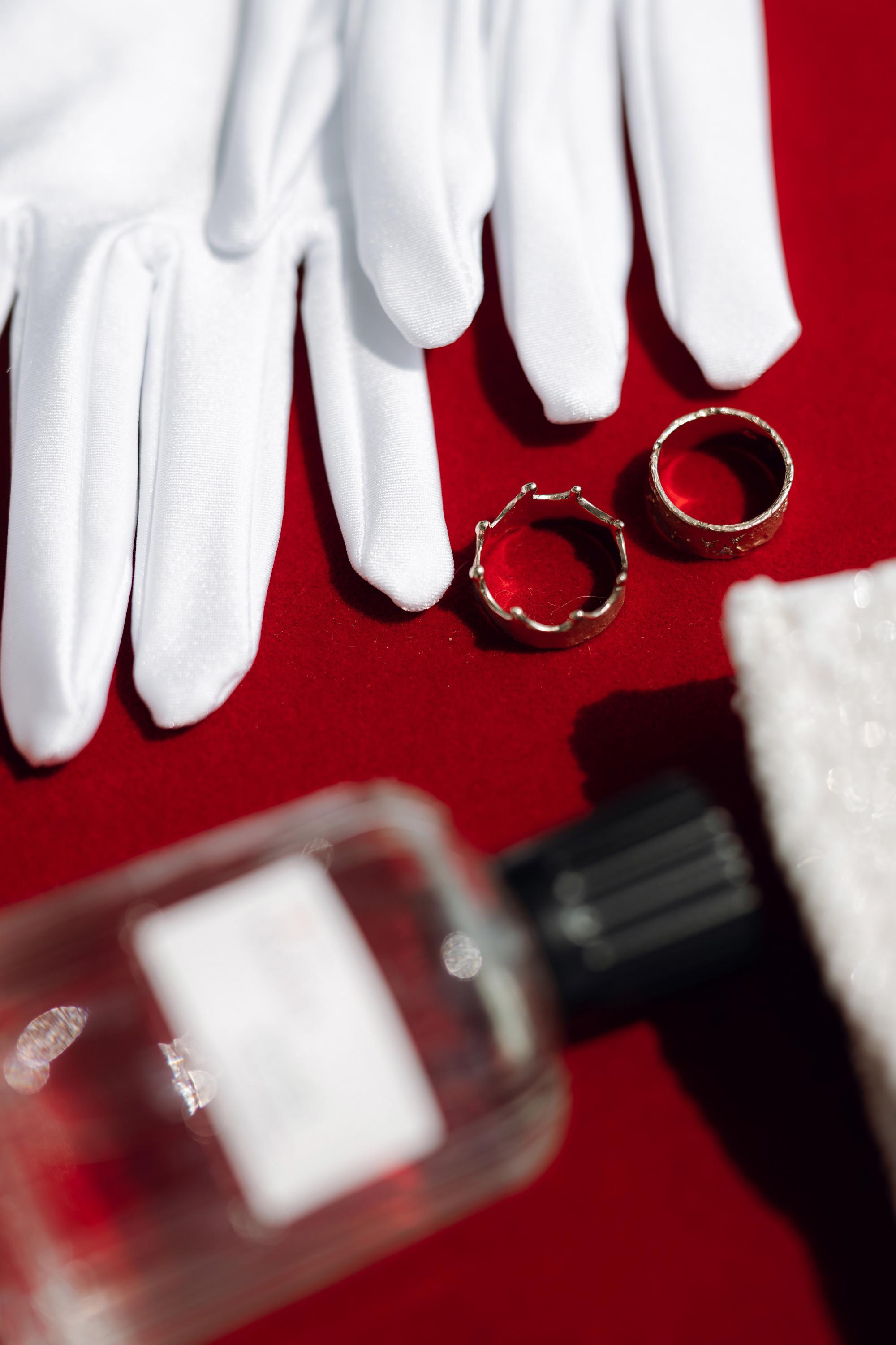a pair of gloves and a ring on a red table