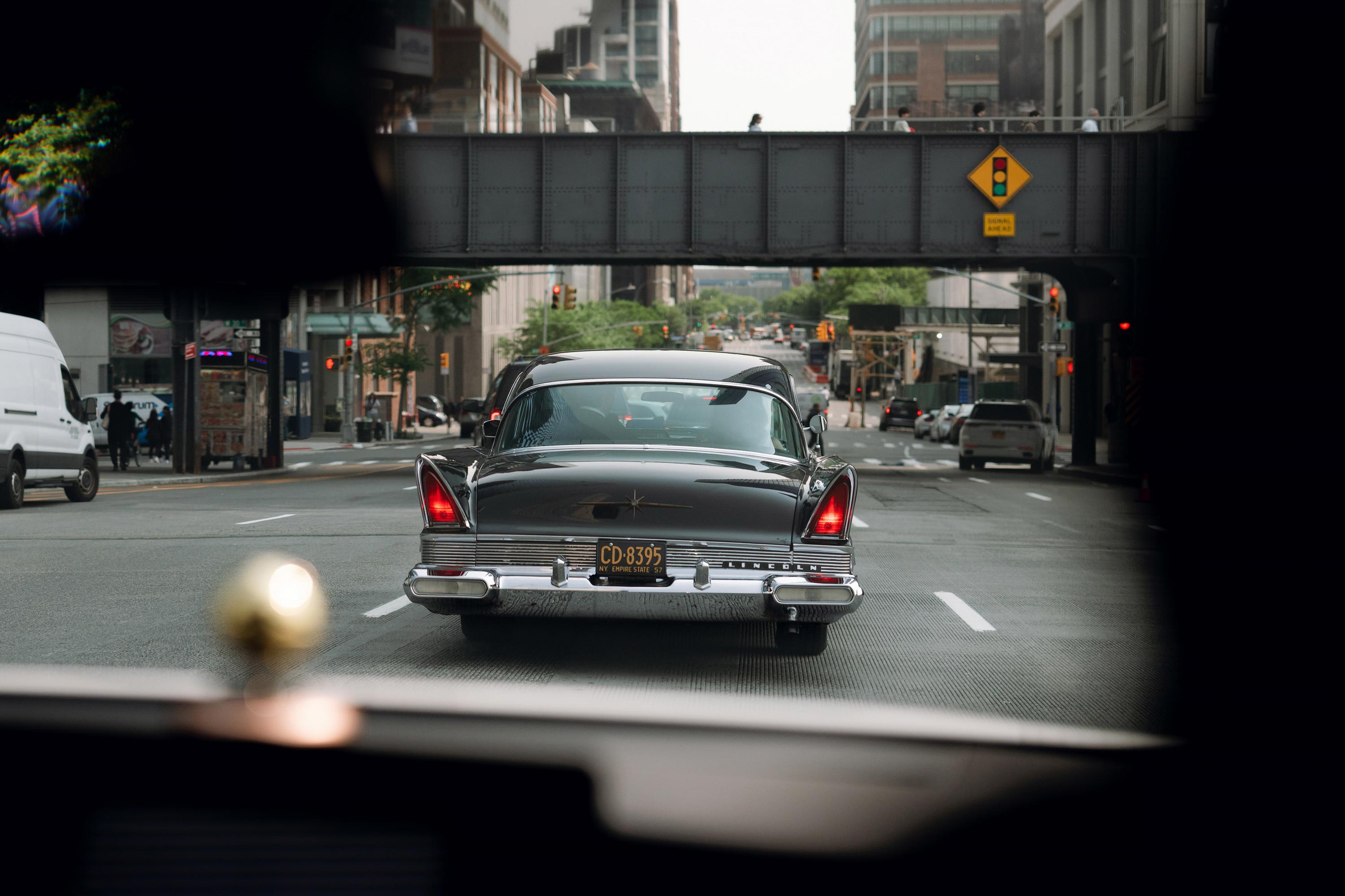 a car driving down a street with a bridge in the background