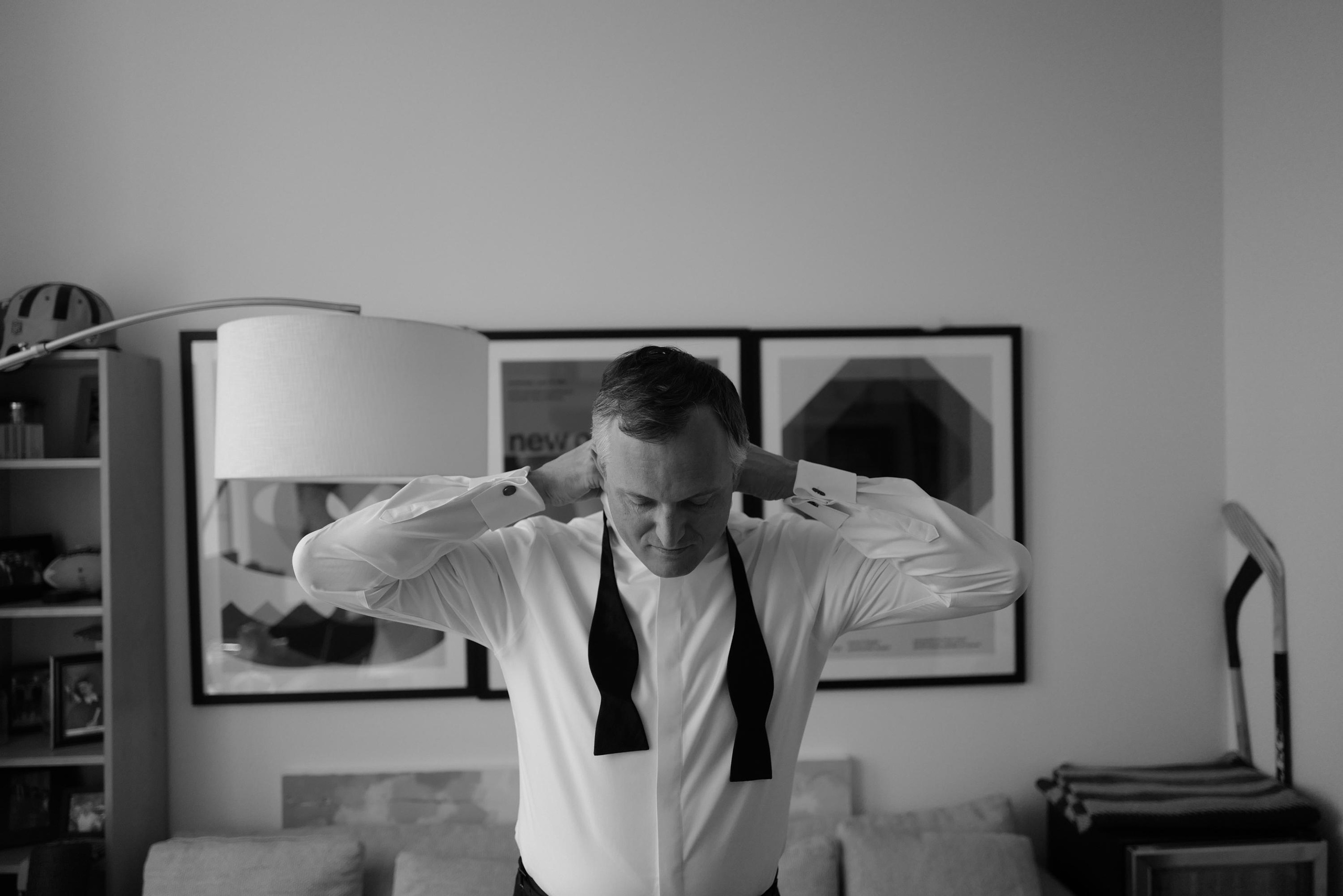 a man in a tie is standing in a living room