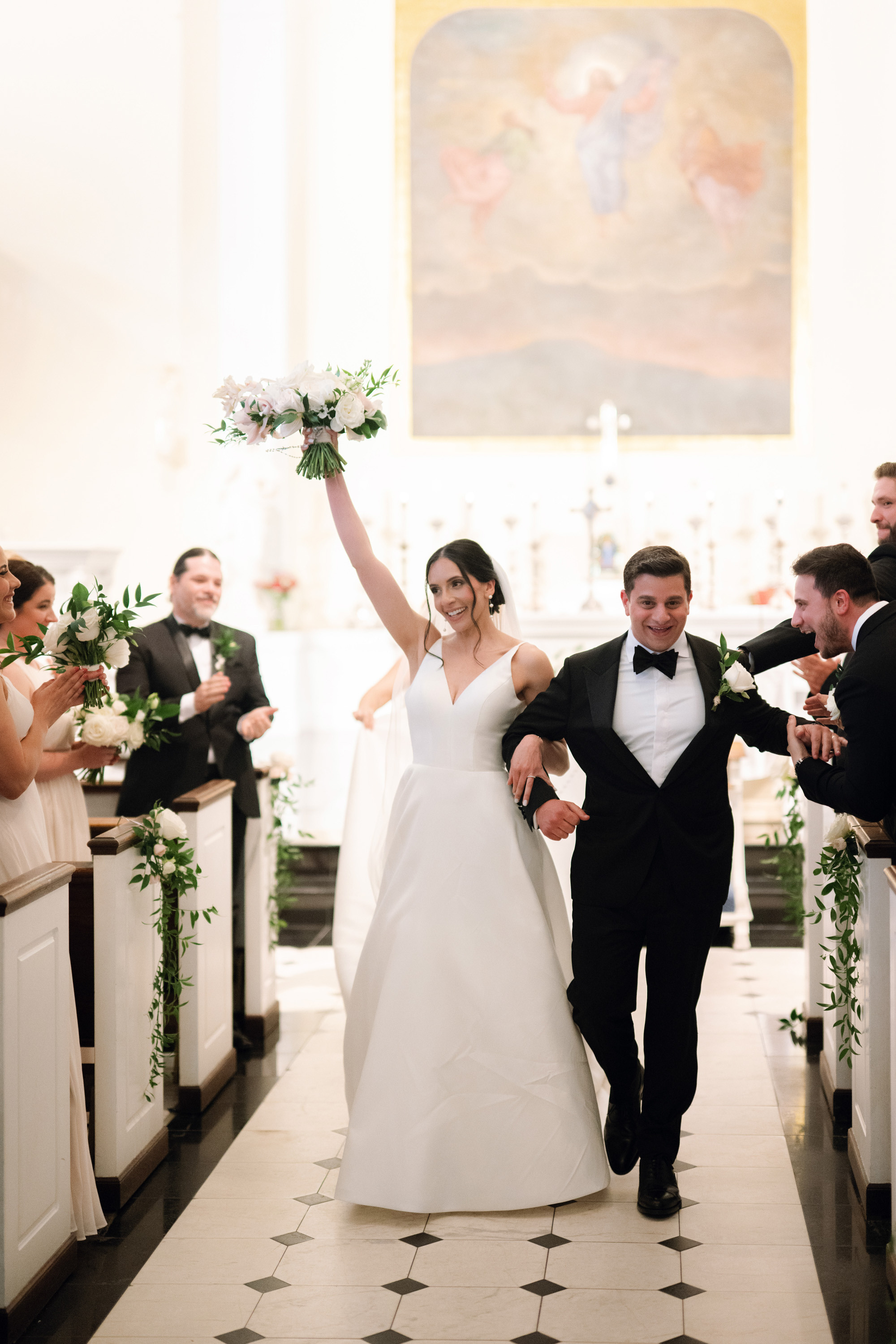 a bride and groom walking down the aisle