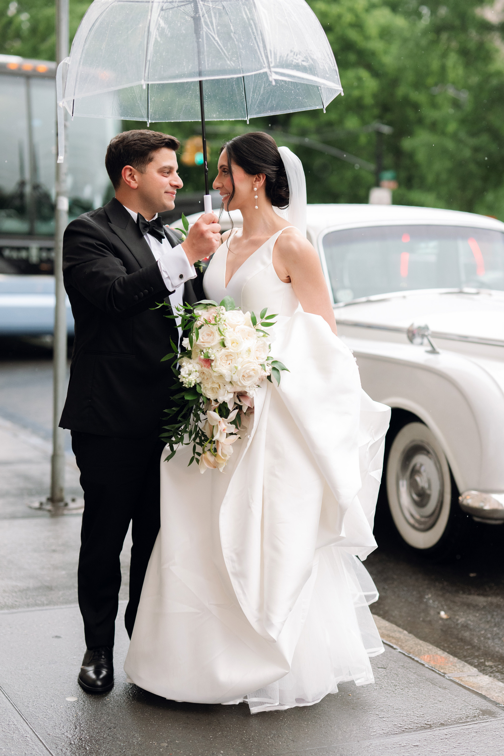 a bride and groom pose under an umbrella