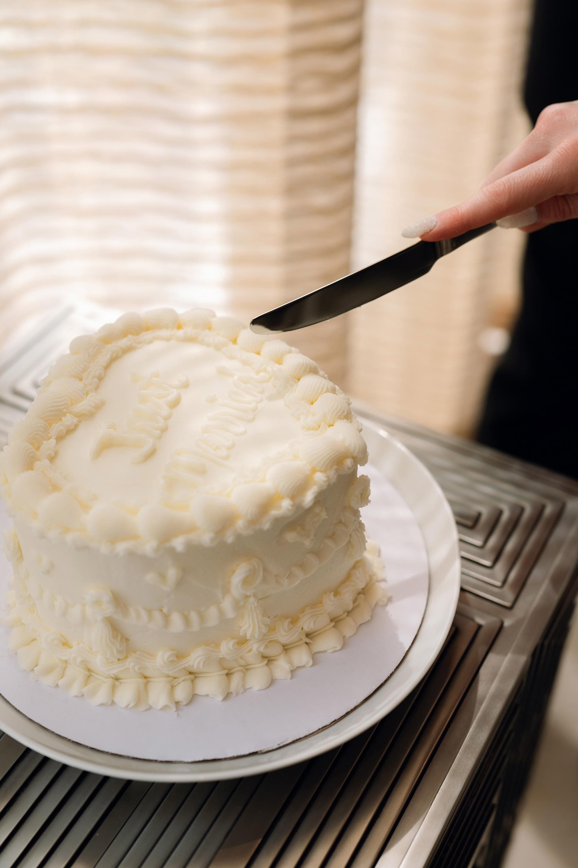 a person cutting a cake with a knife